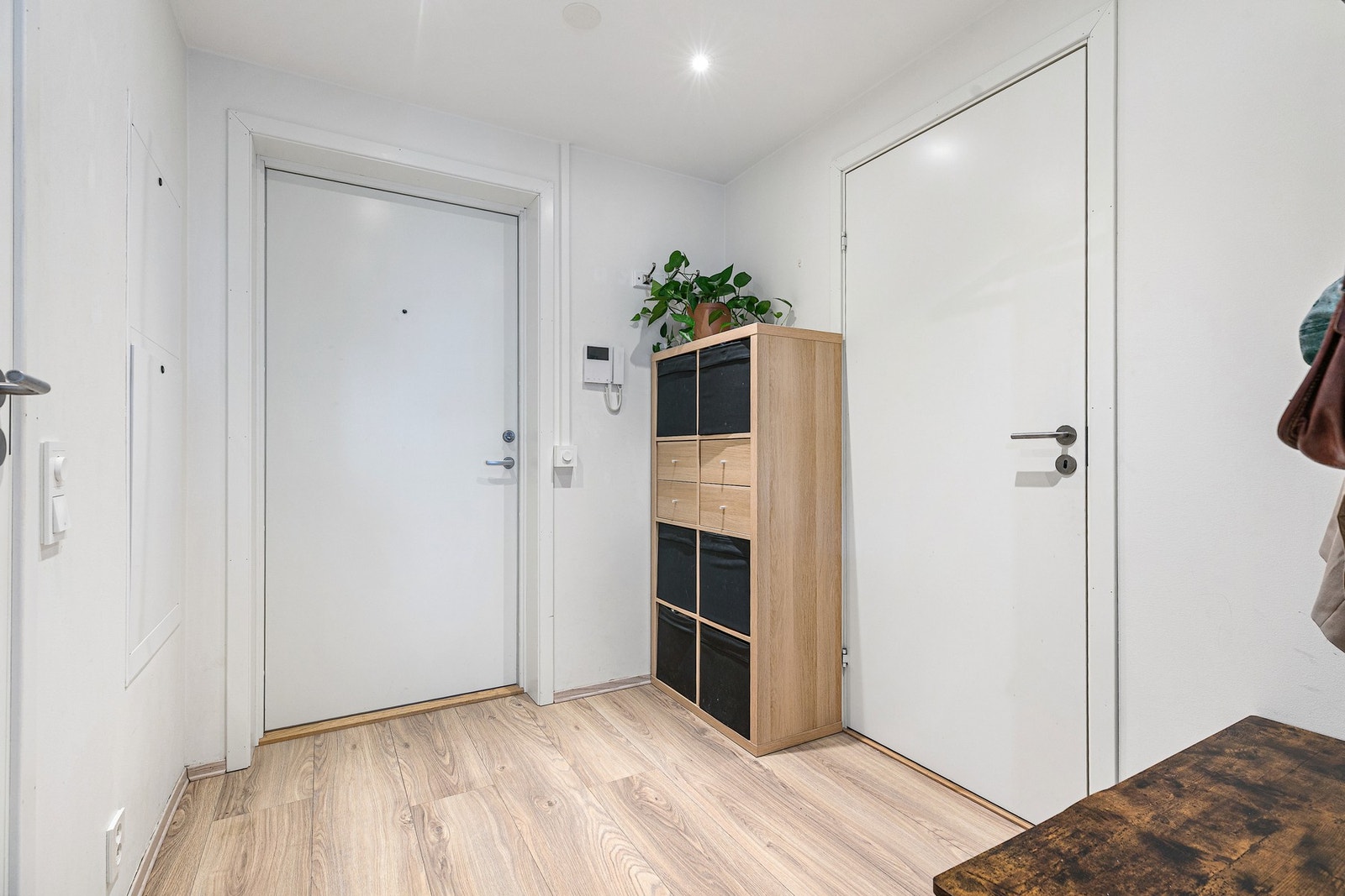 Lyst inngangsparti med parkettgulv og hvite vegger. Galleribilde