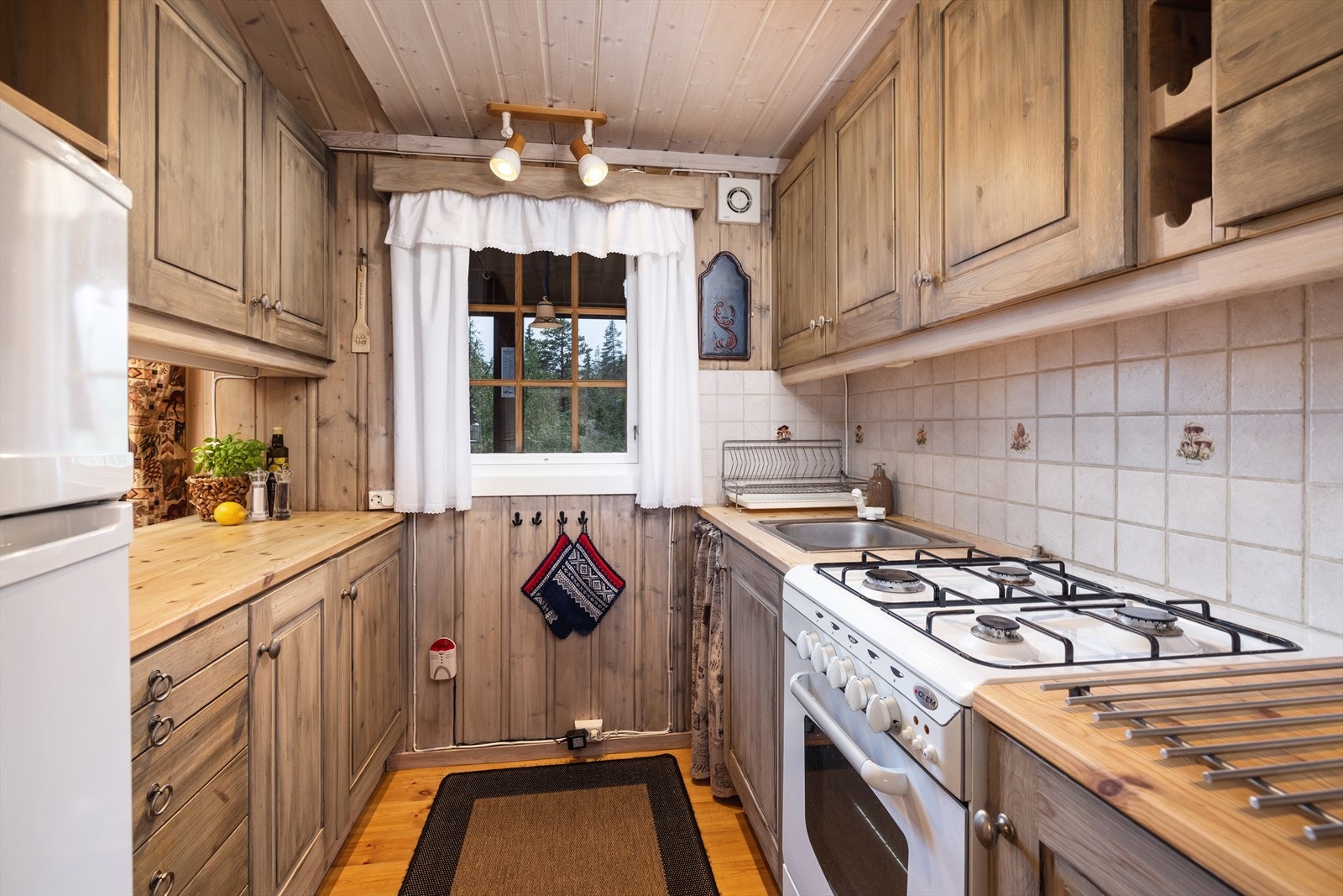 Tiltalende "hyttekjøkken" med profilerte fronter og benkeplate av heltre. Galleribilde