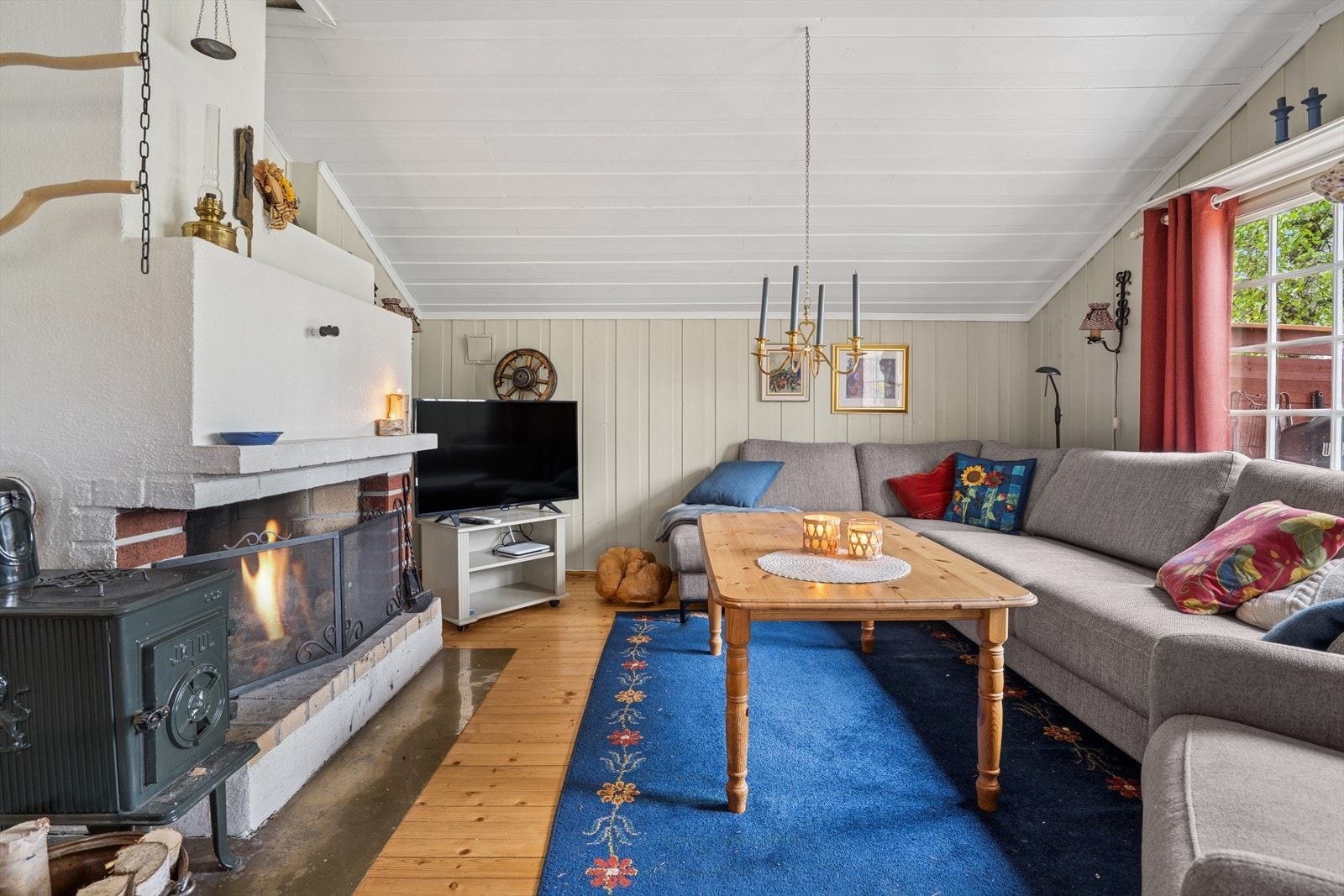 Åpen peis i stuen for kos, ellers er det vedovn for oppvarming. Galleribilde