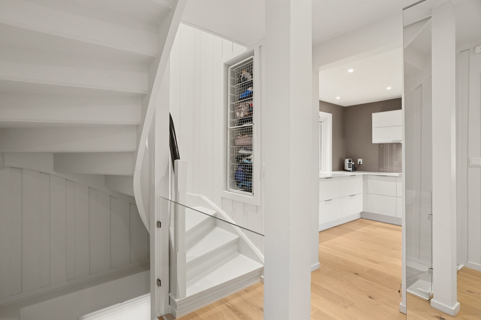 Fra gangen er det trapp til kjelleretasjen og 2.etasje. Garderobeskap med speildører i gangen samt nisje med plass til trådkurver i trappen. Galleribilde