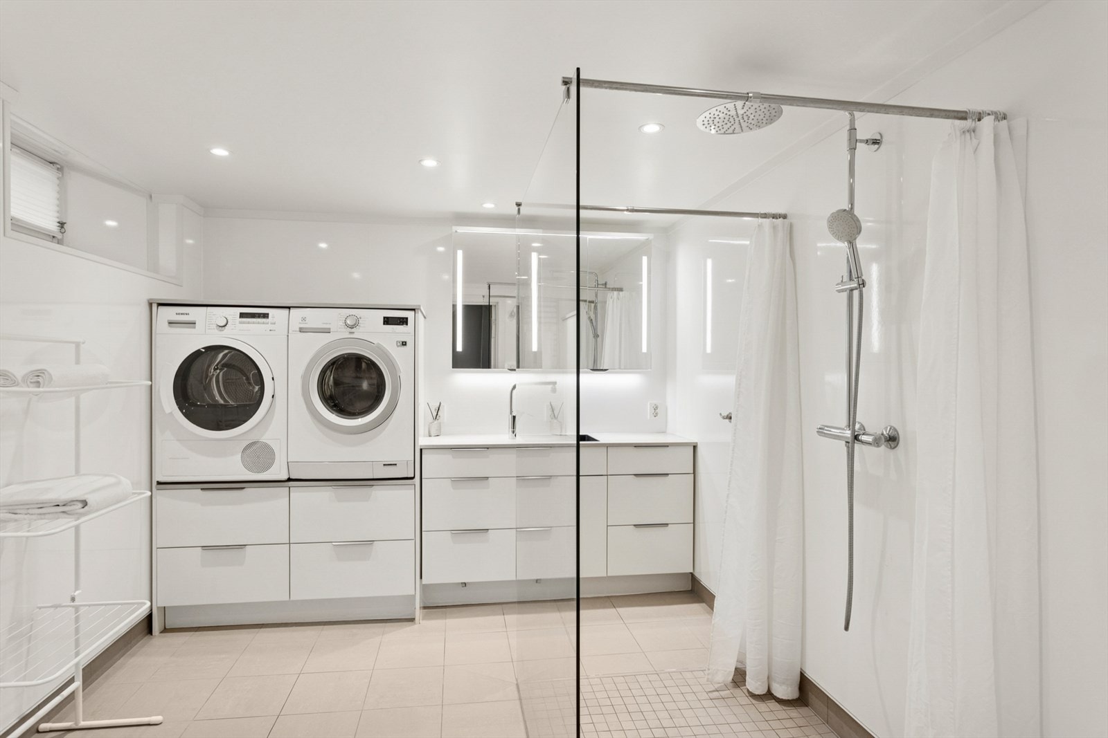 Bad/vaskerom i kjeller. Rommet ble pusset opp i 2019 og har baderomsplater på veggene og flislagt gulv med elektriske varmekabler. Galleribilde