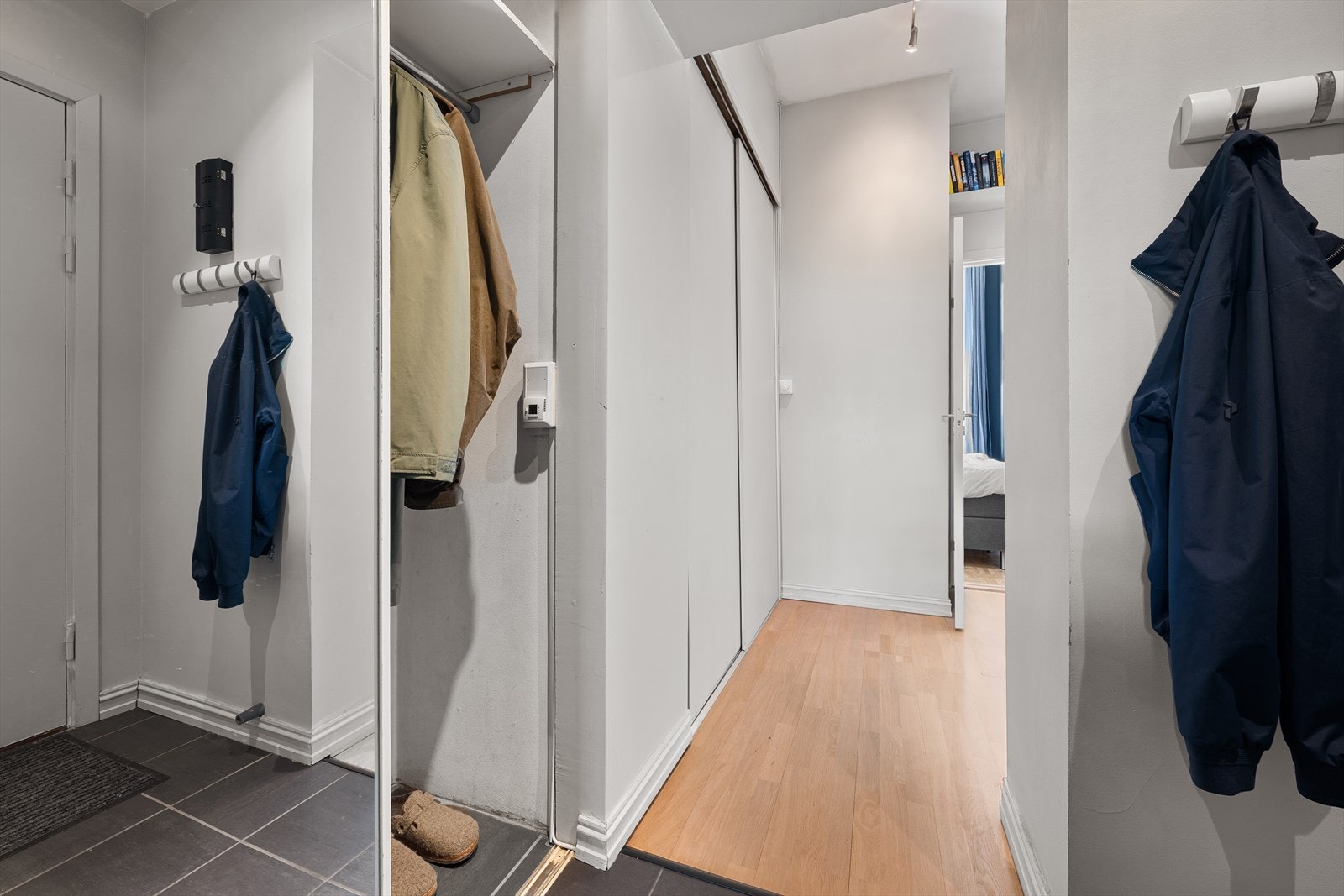 Velkommen inn! Her blir du møtt av en lys og romslig entré med rikelig lagringsplass i to store skyvedørsgarderober. Galleribilde