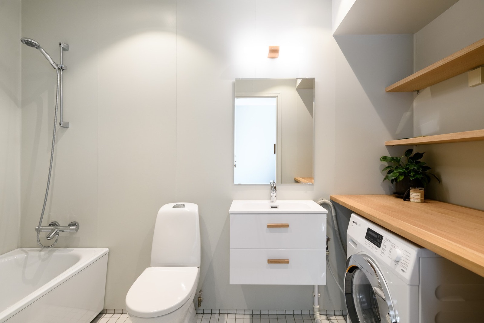 Romslig bad med badekar og opplegg til vaskemaskin. Galleribilde