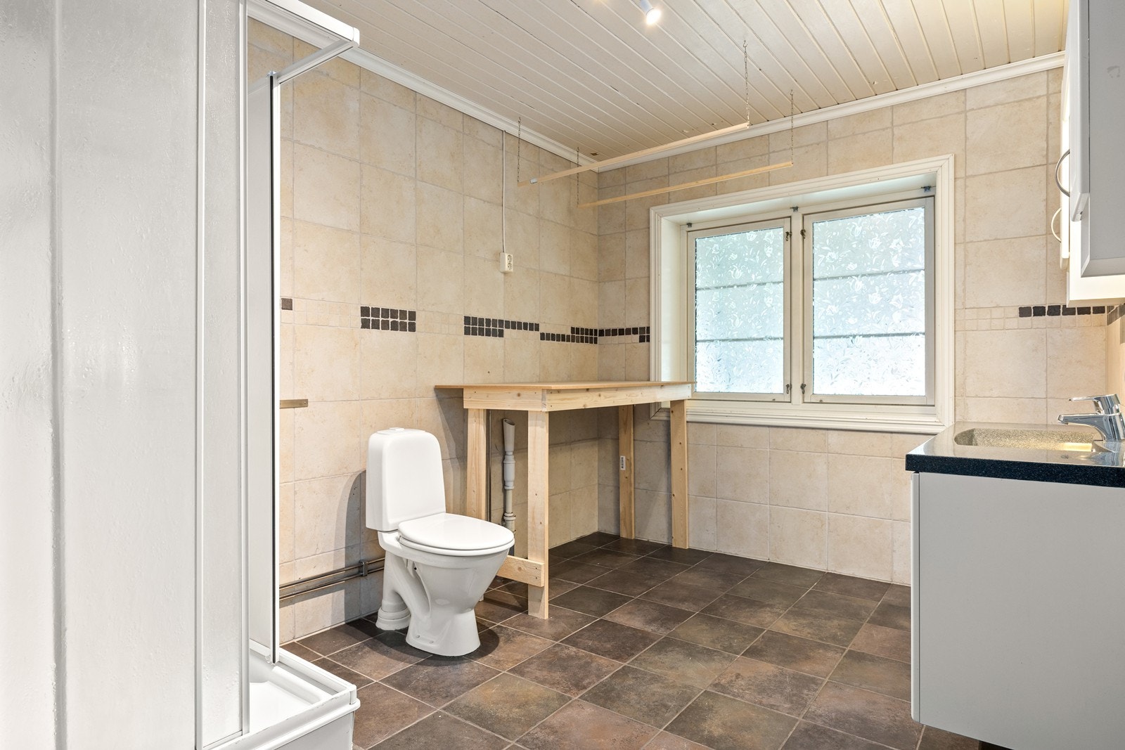 Bade er innredet med servant på skap, stående toalett og dusjkabinett. Galleribilde