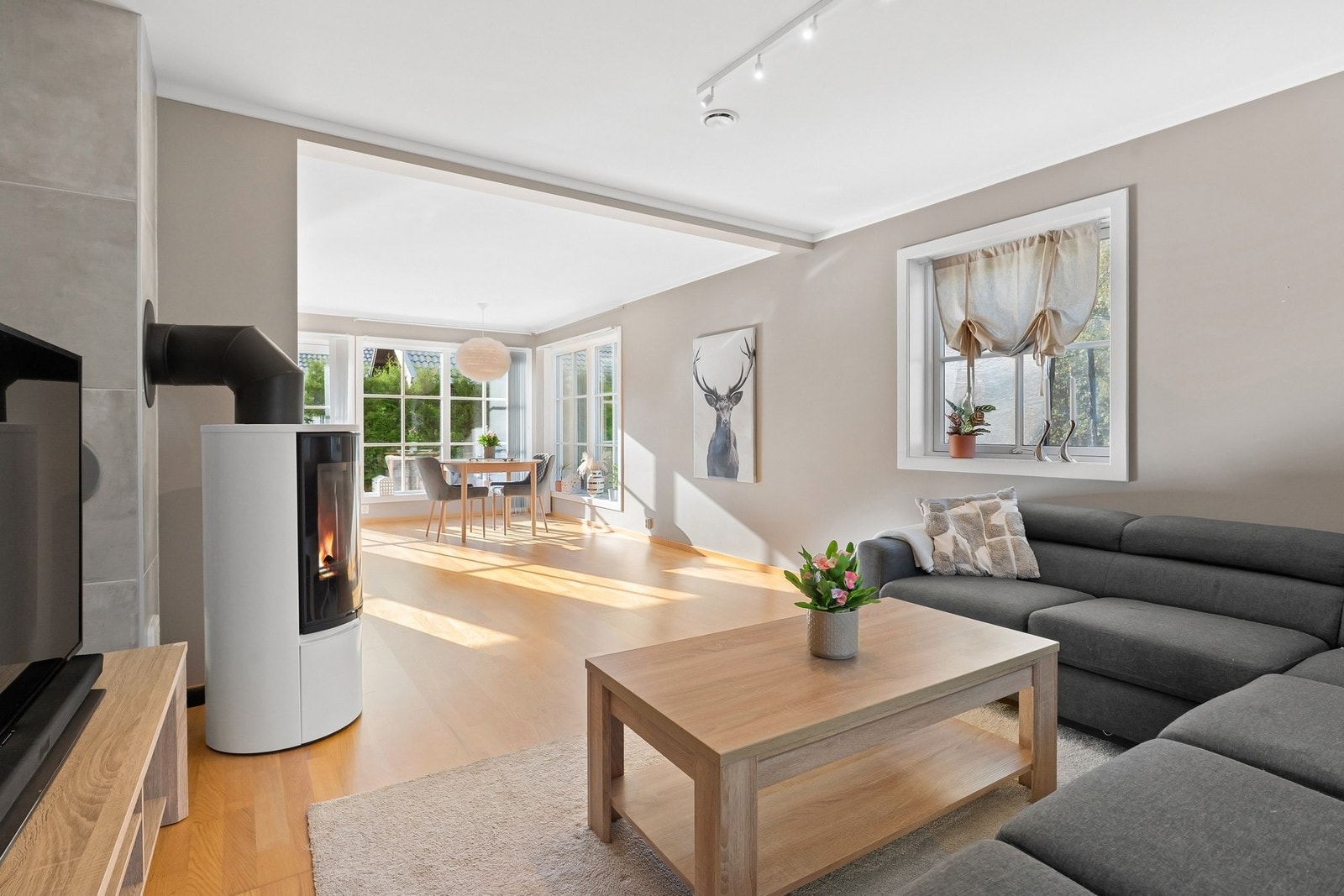 Stuen har et koselig hjørne med tilhørende vedovn. Galleribilde