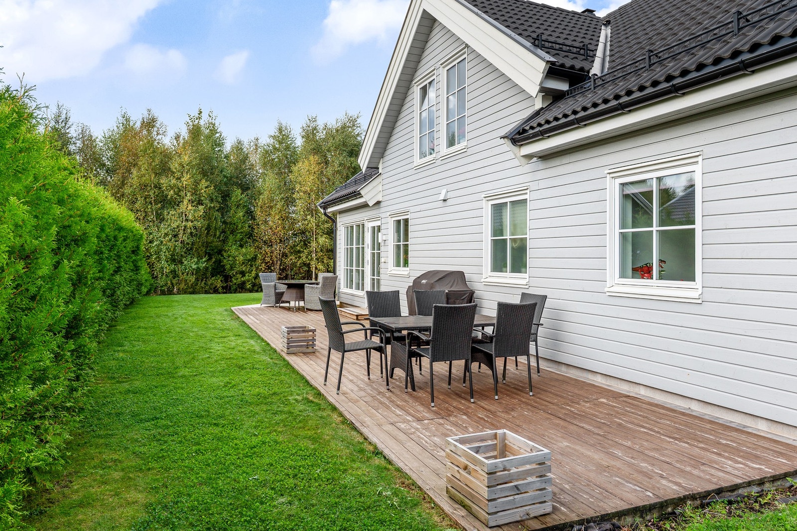 Verandaen strekker seg rundt hjørnet med direkte utgang på plenen - perfekt for barna! Galleribilde