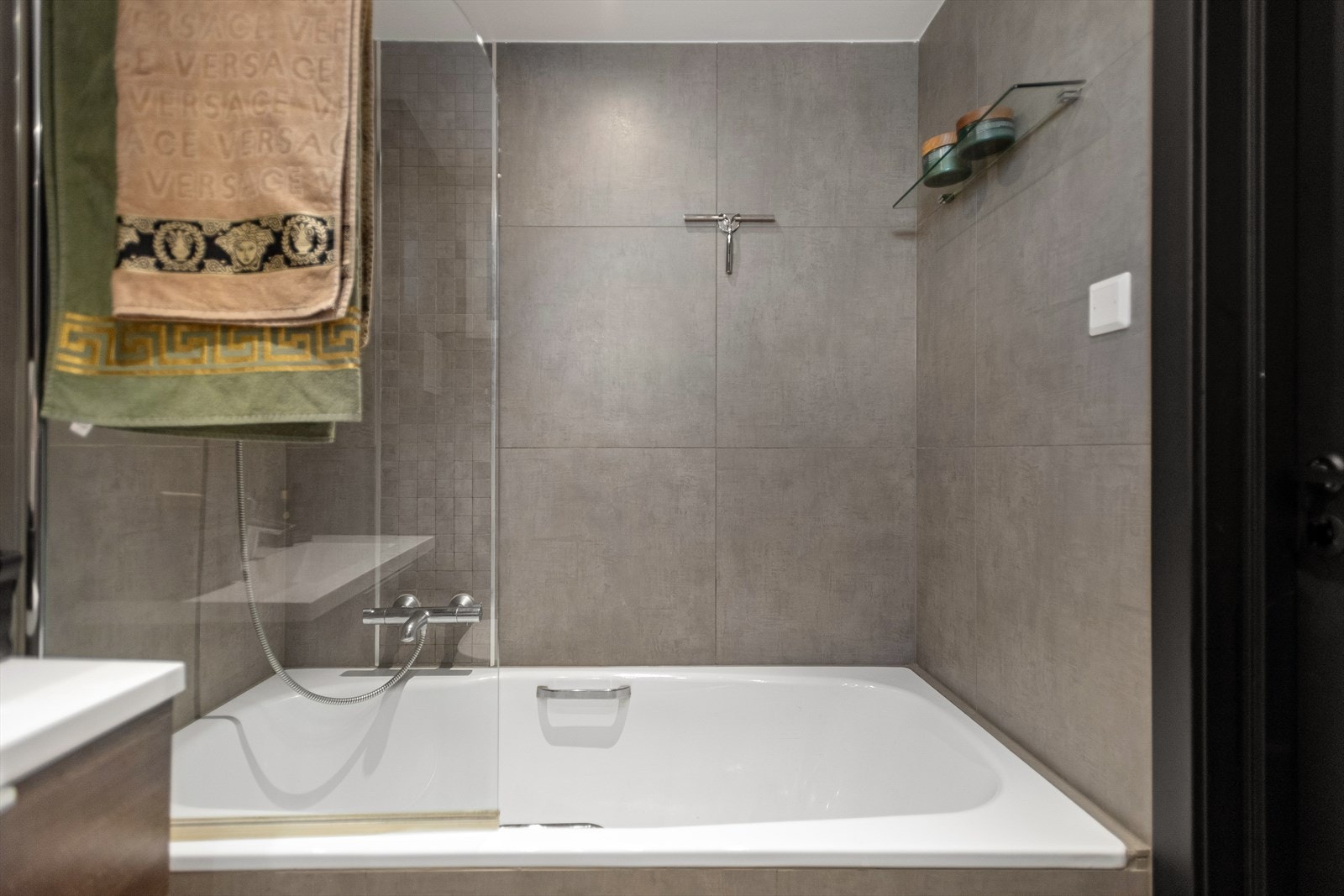 Badet er innredet med badekar, separat dusj, vegghengt toalett med hånddusj og servant med benkeskap Galleribilde