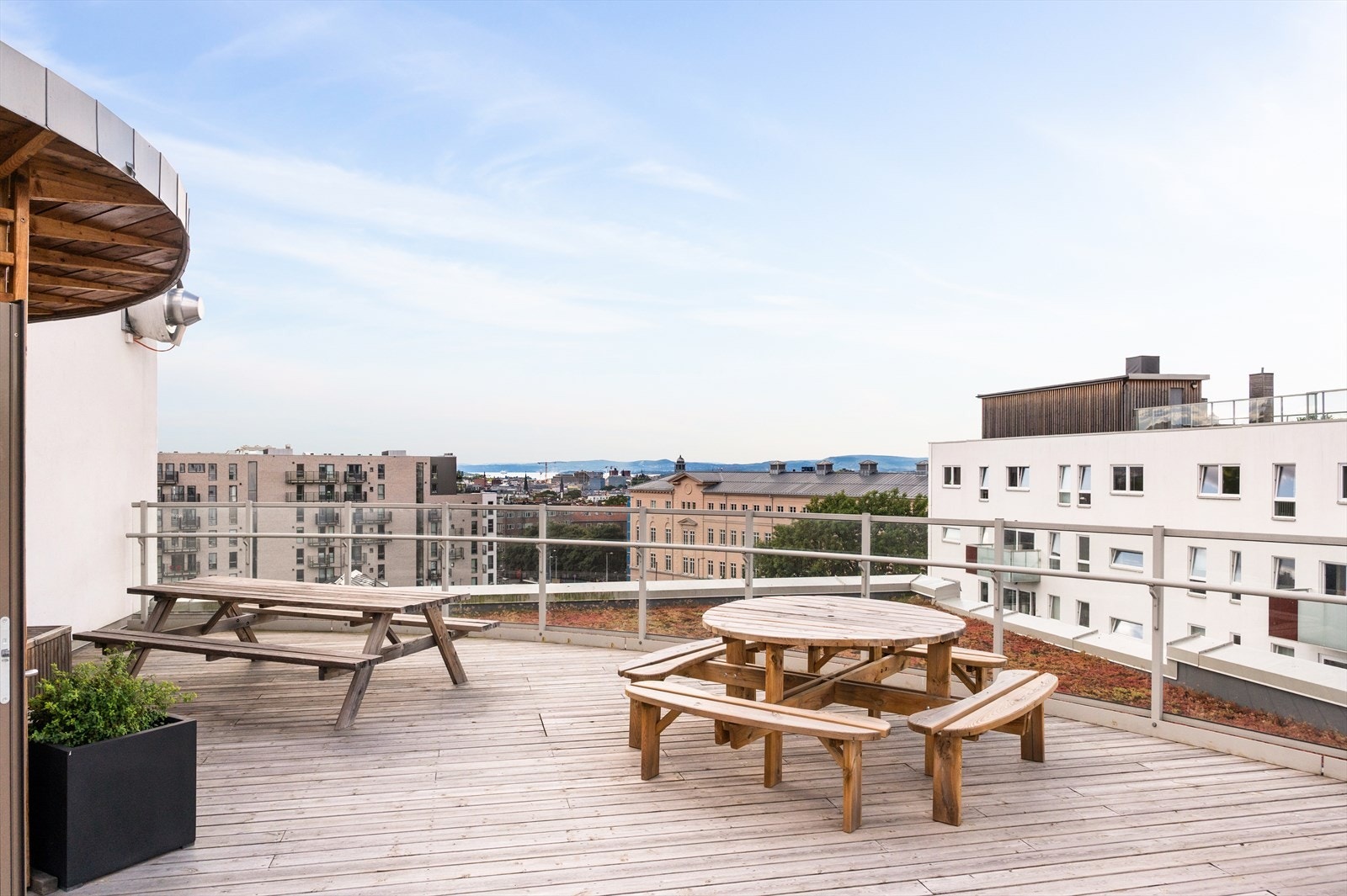 Stor, felles takterrasse med flere sittegrupper og hyggelig beplantning. Galleribilde
