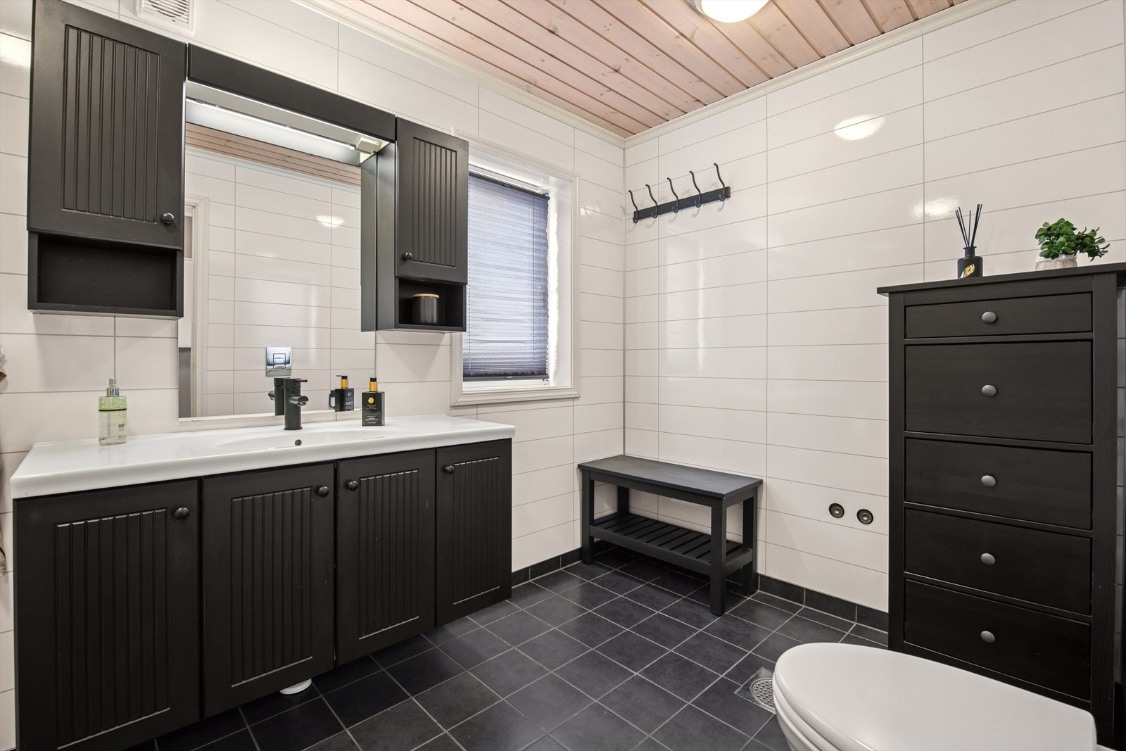 Bad/vaskerom er delikat innredet med dusjkabinett, opplegg for vaskemaskin, toalett og servant med møbel. Elektrisk styrt vifte. Galleribilde