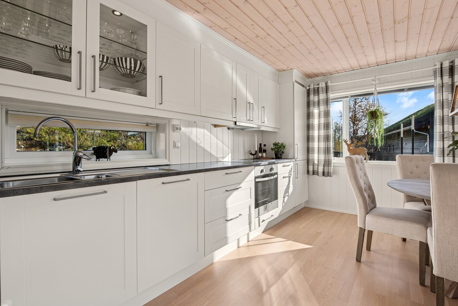 Et lite vindu ved kjøkkenbenken gir naturlig lys inn i rommet og bidrar til en lysere arbeidsflate. Galleribilde