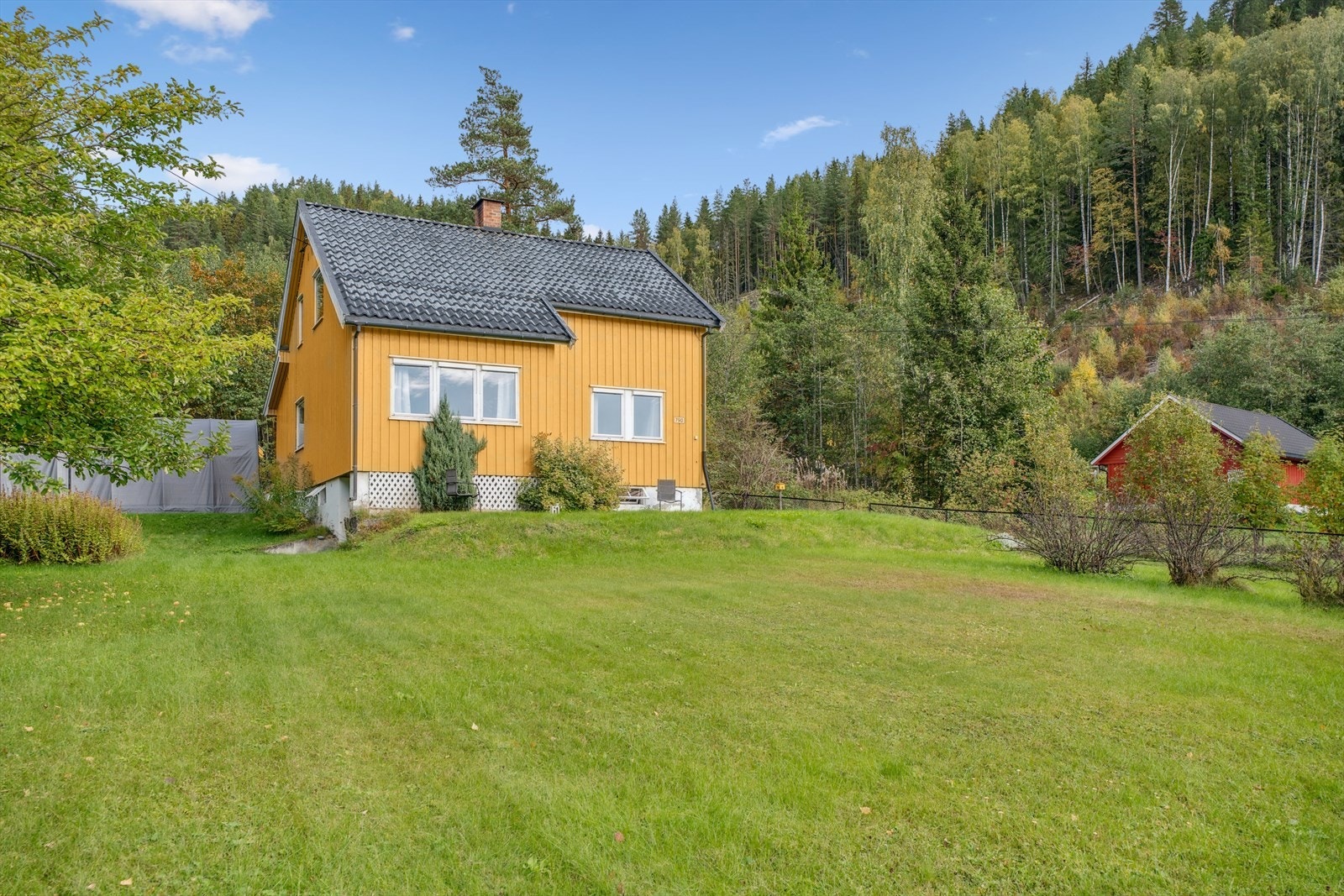 Tomt på 991,2 m² med hage, beplantning og gruset gårdsplass Galleribilde