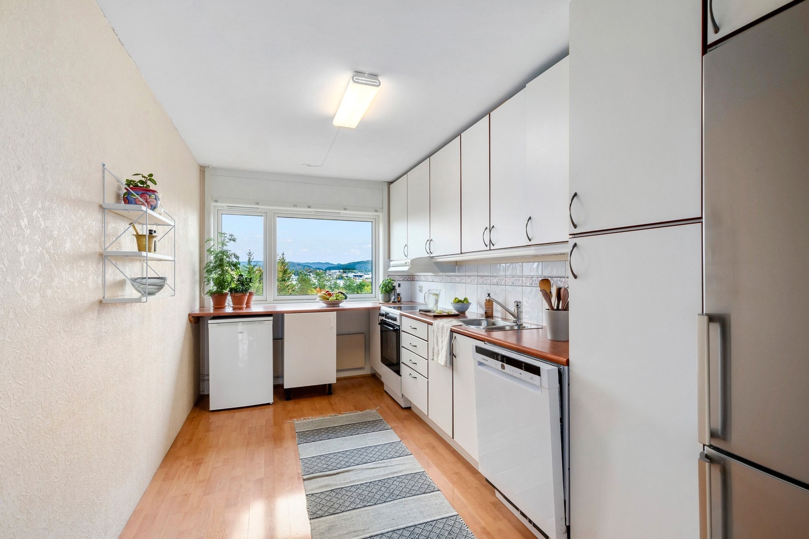 Kjøkkene fra 2006 med lyse flater og god benkplass.
Ny oppvaskmaskin og komfyr fra 2024. Galleribilde