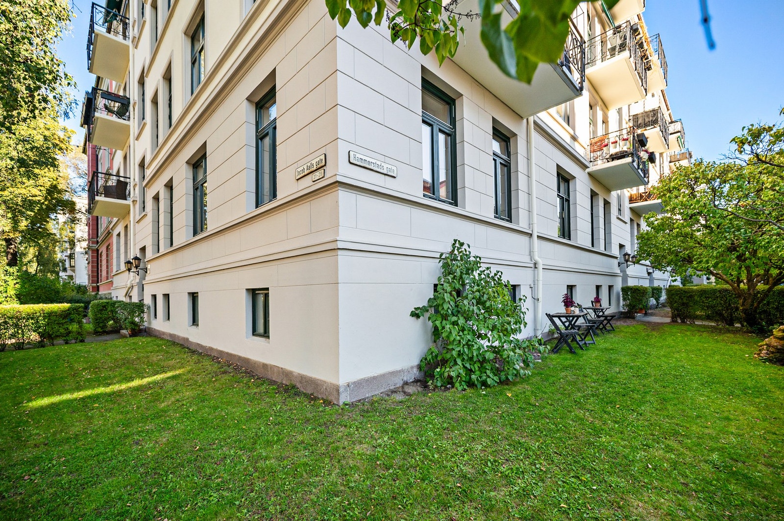 Hjørnebygård med pent opparbeidet forhage og sittegruppe. Galleribilde
