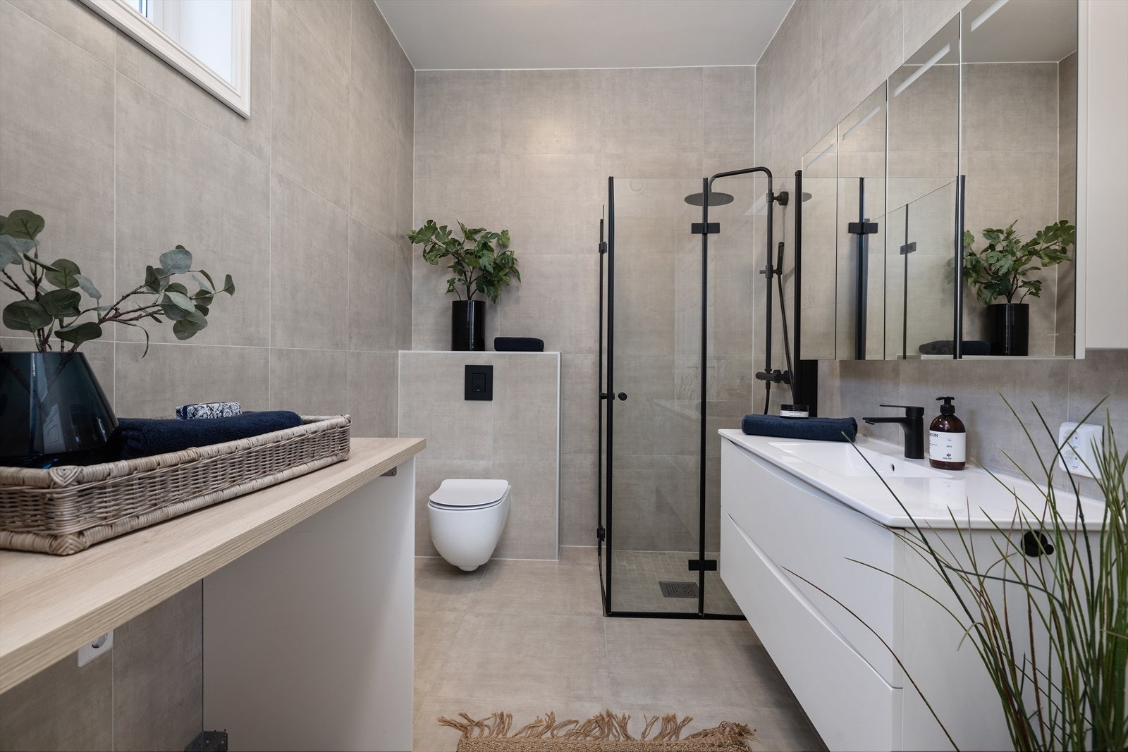 Badet har praktisk benk hvor man kan ha vaskemaskin og tørketrommel under Galleribilde