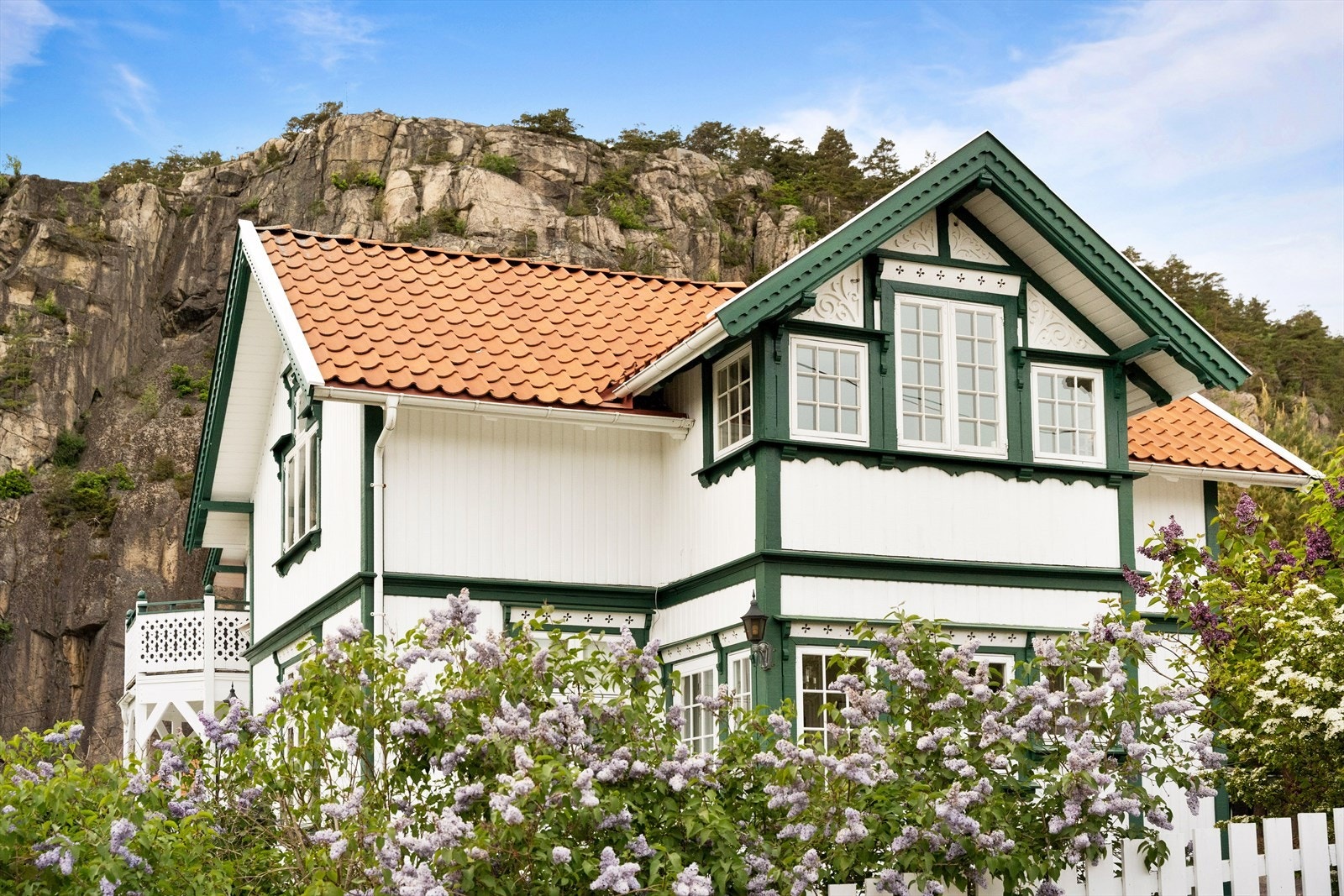 Elegant fasade med klassiske sveitserdetaljer - utskårne mønstre, profilerte vindusomramminger og gesimsbånd som gir et autentisk uttrykk av 1800-tallets arkitekturtradisjon. Galleribilde