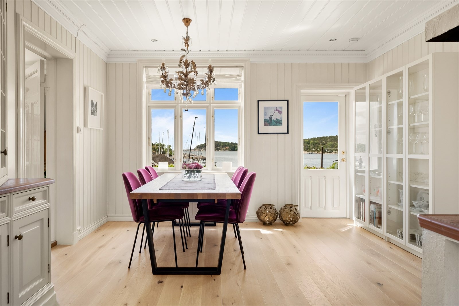 Lys og innbydende spisestue med vakker utsikt mot sjøen - her nytes måltidene med panoramablikk over Hankøsundet. Rommet ligger i tilknytning til kjøkkenet og har direkte utgang til hagen. Galleribilde