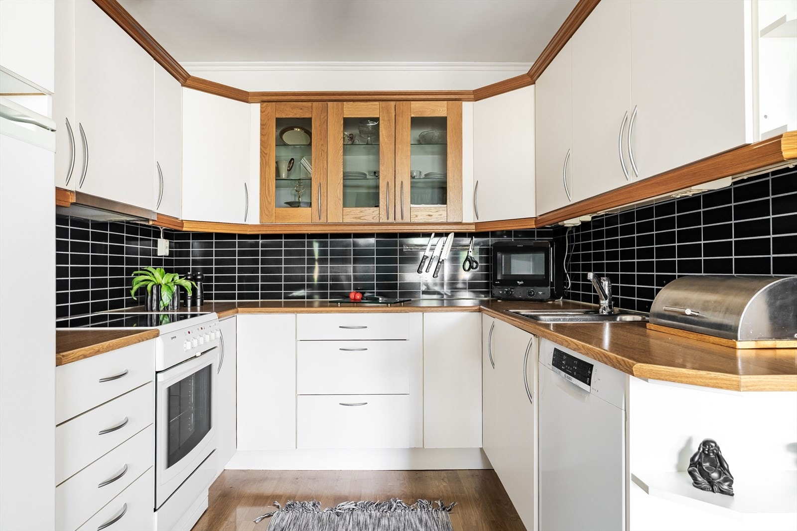 Kjøkkenet er innredet med klassiske, lyse fronter og en benkeløsning som gir godt arbeidsrom. Her er det lett å se for seg hverdagsmåltidene - eller å dekke til større selskap. Galleribilde