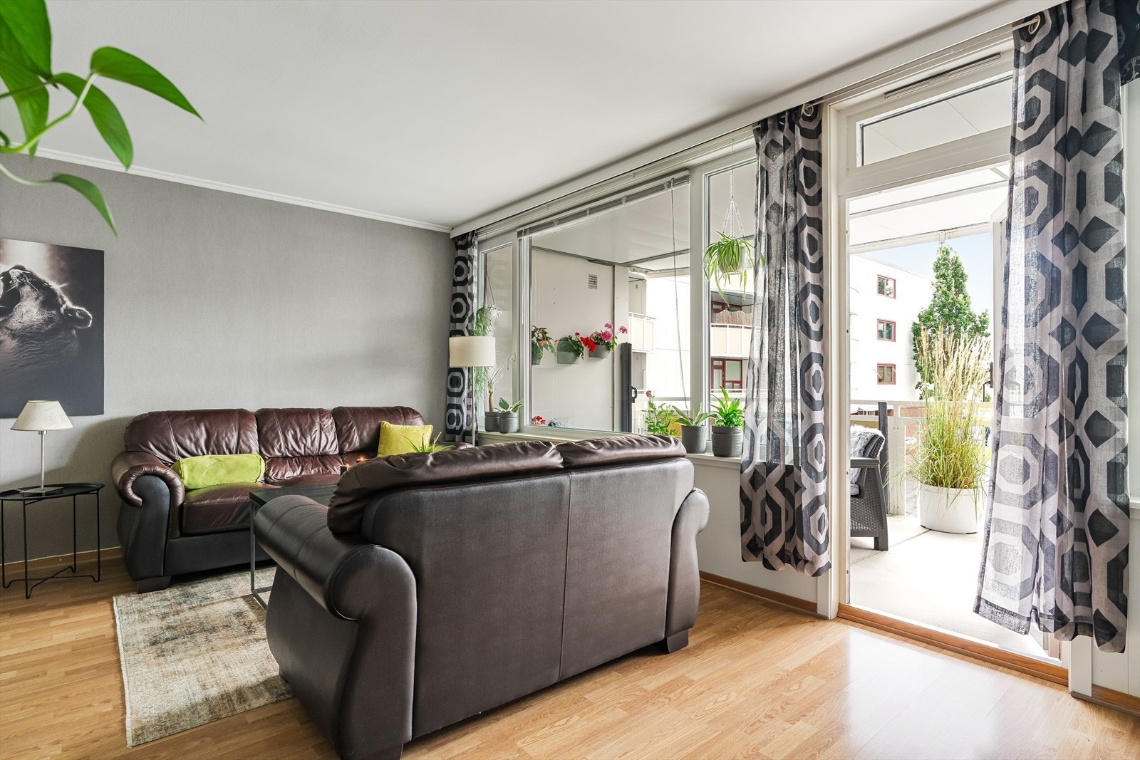 Her samles familie og venner rundt salongbordet - med balkongdøren åpen forlenges rommet naturlig ut til den solrike uteplassen. Galleribilde