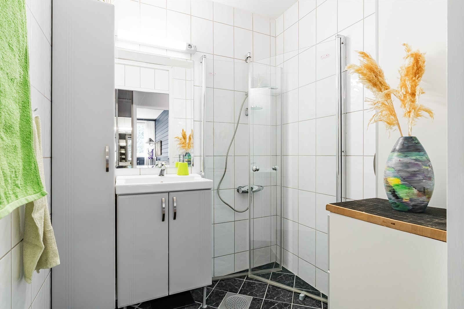 Lyst og funksjonelt bad med dusjhjørne, servant med underskap og speil. Et rom med alt du trenger i en travel hverdag. Galleribilde