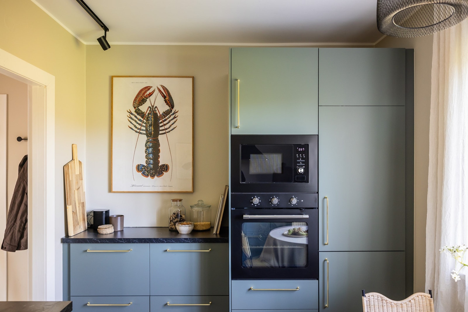 Kjøkkeninnredningen er stilren og lekker med glatte fronter og laminat benkeplate med planlimt kompositt oppvaskkum. Galleribilde