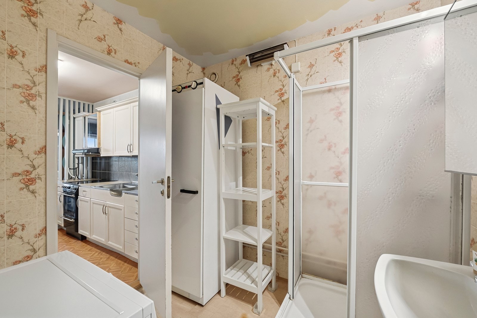 Bad/vaskerom har vinylbelegg på gulv, baderomstapet på vegger og er utstyrt med dusjkabinett, servant og røropplegg til vaskemaskin. Galleribilde