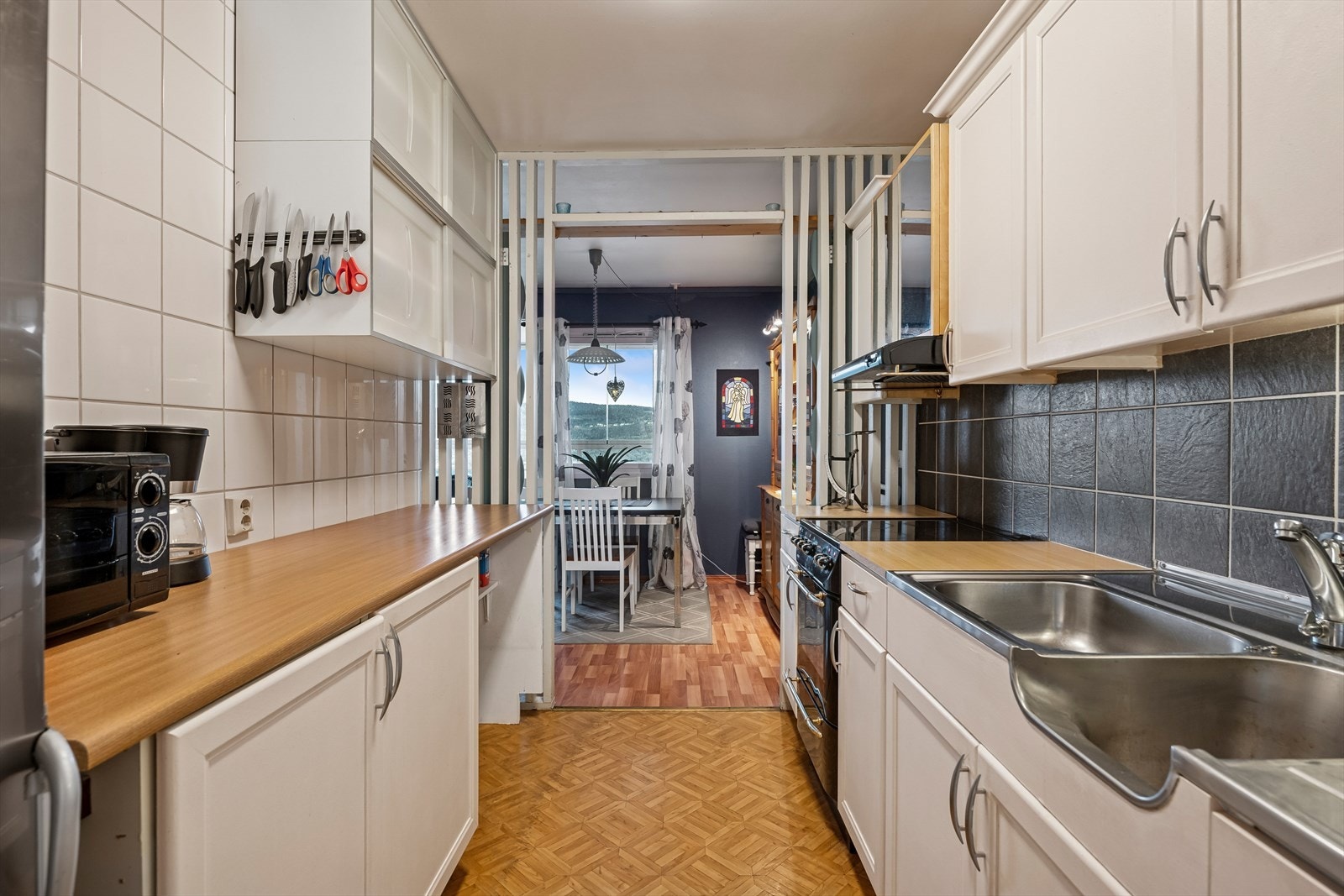 Bruksvennlig kjøkken plassert i eget rom med spilevegg ut mot spisestuen. Galleribilde