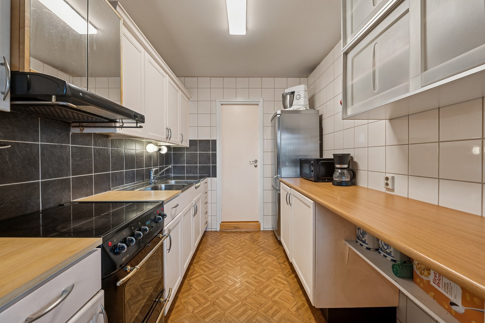 Innredning med lyse, profilerte fronter og laminat benkeplate med nedfelt oppvaskkum. Galleribilde