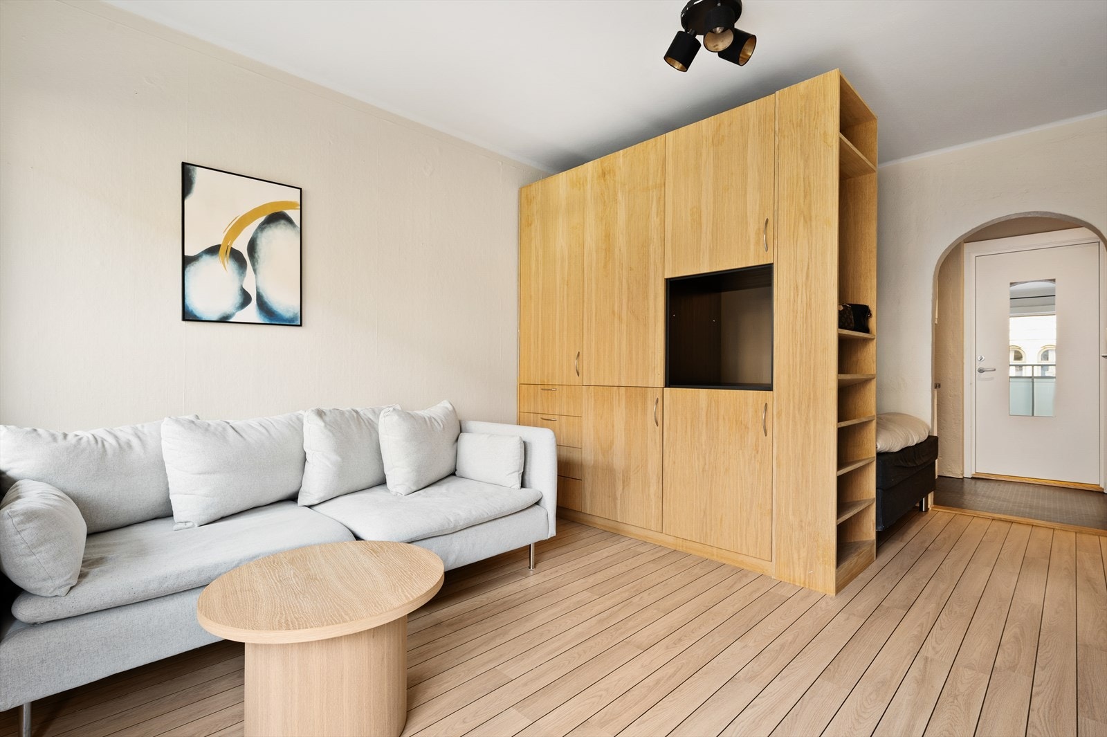 Det er en møbelsnekret skillevegg med skap som skiller stue og soveplass. Denne kan flyttes avhengig av ønsket størrelse på sengen. Galleribilde