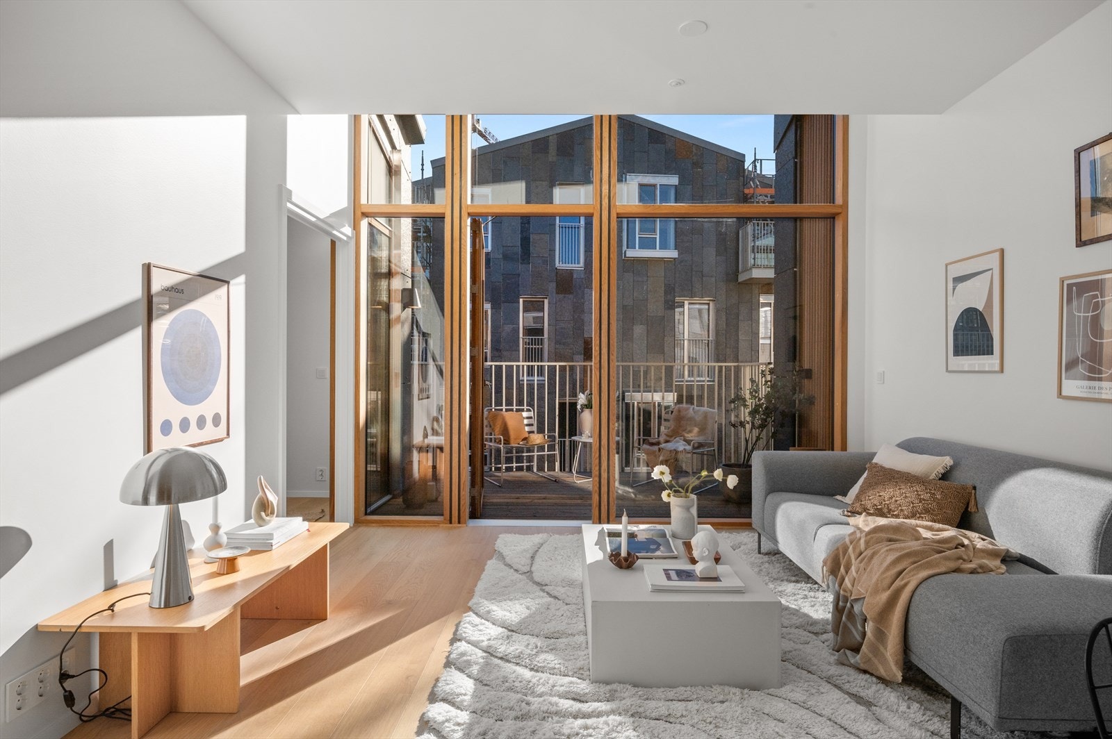 Stuen og kjøkkenet smelter sømløst sammen i en åpen og luftig planløsning med rause vindusflater fra gulv til tak. Galleribilde