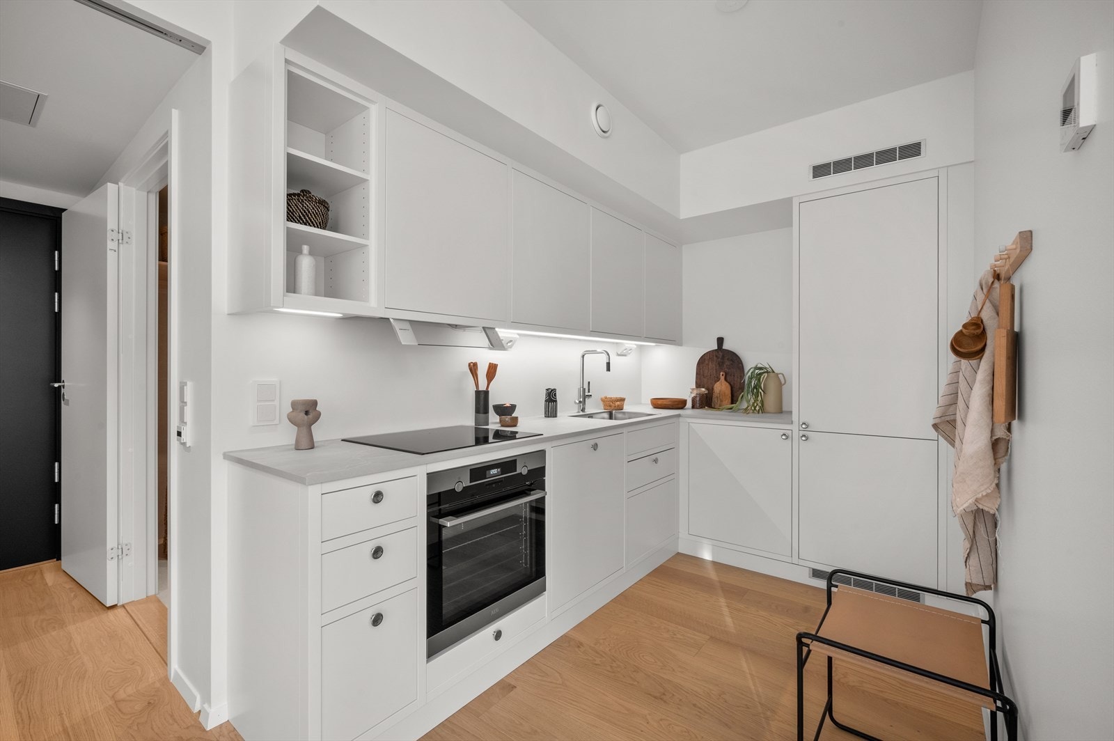 Her finner du alt av integrerte hvitevarer: kjøl/frys, oppvaskmaskin, stekeovn, induksjonstopp samt komfyrvakt og mekanisk avtrekk - alt tilrettelagt for både hverdagens raske måltider og selskapelige anledninger. Galleribilde