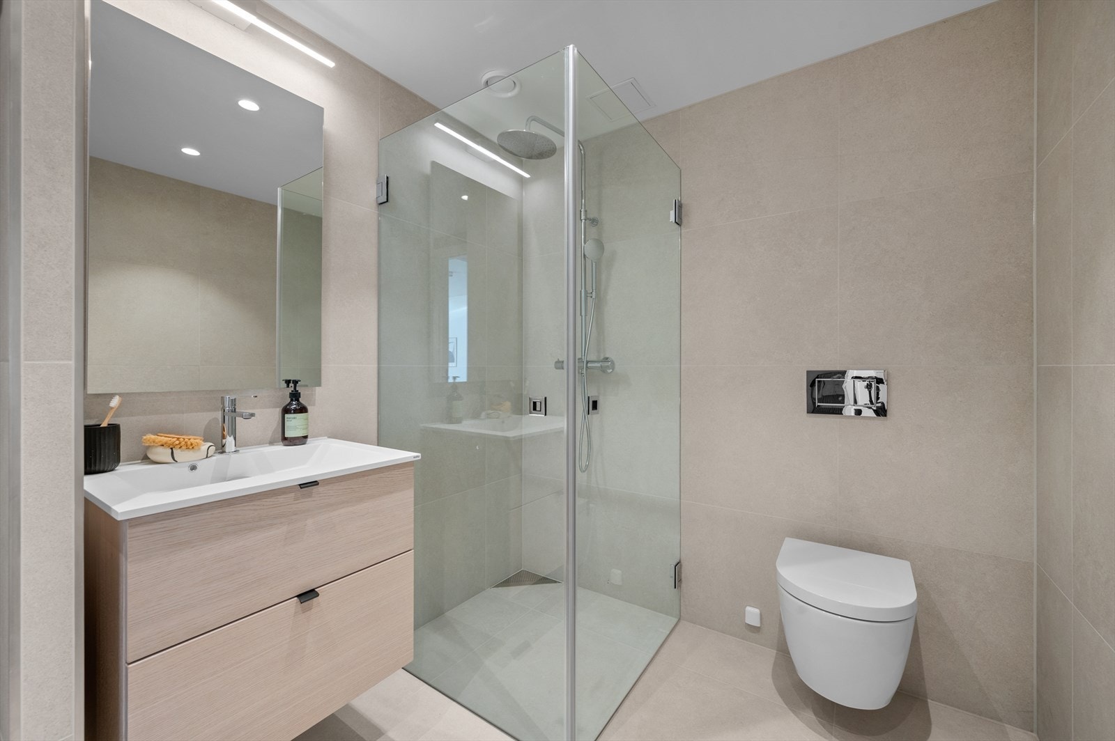 Badet er gjennomført i moderne og delikate materialer, med store, matte Grespor Milestone White 60x60 cm fliser på både gulv og vegger. Galleribilde