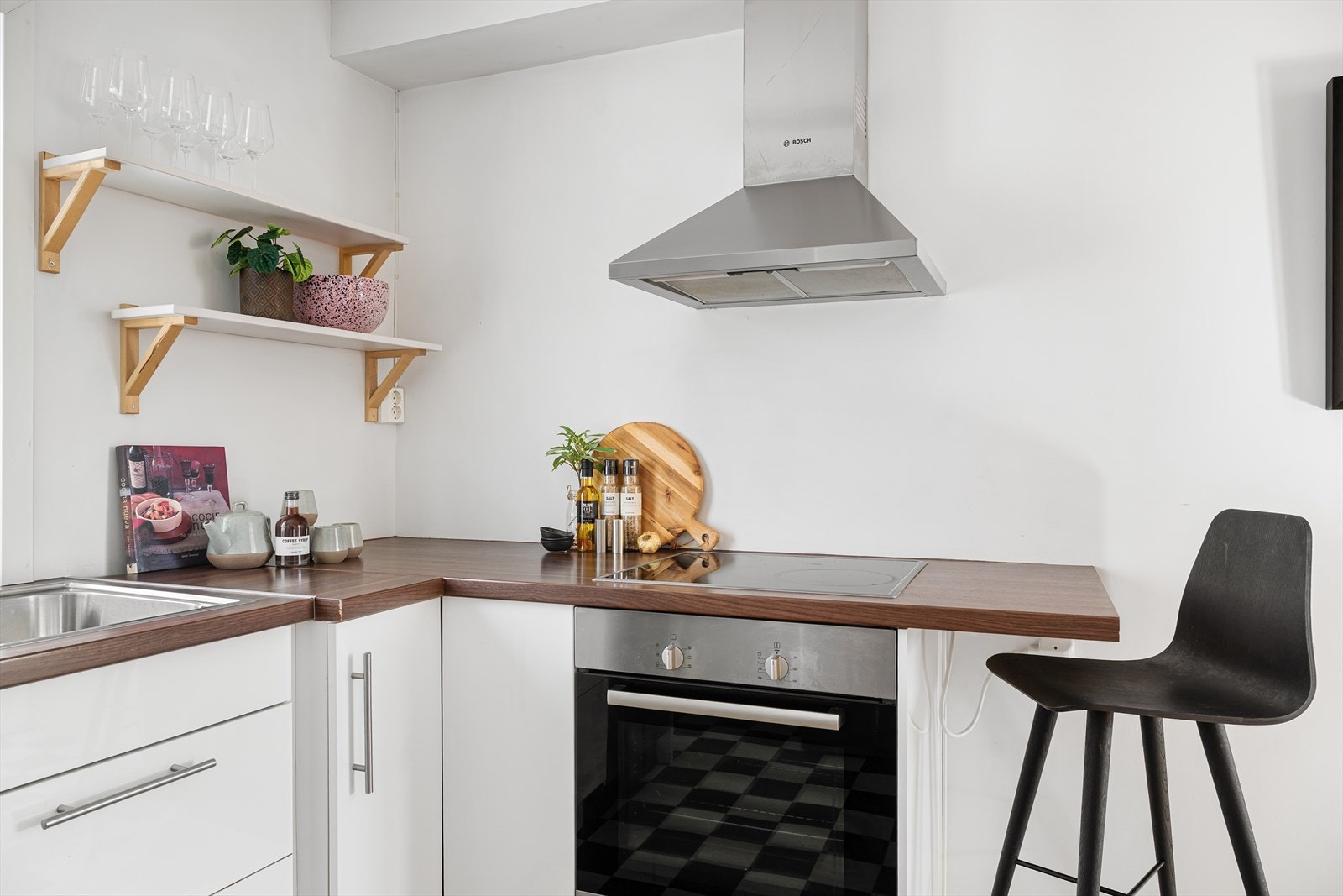 Kjøkken med hvite fronter, mørk benkeplate og praktiske åpne hyller Galleribilde