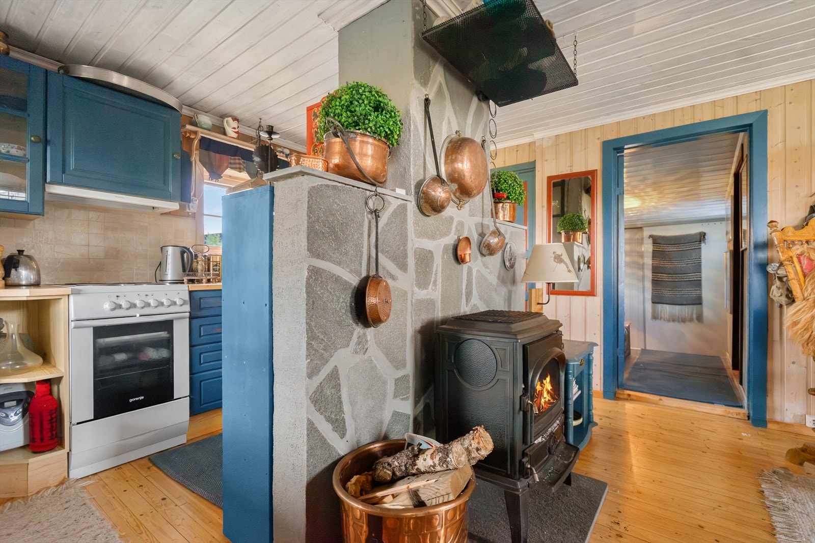 Hyggelig stue med vedovn som sprer varme og gir ekte hyttefølelse. Kjøkkenet ligger like ved, noe som gir en sosial og praktisk romløsning Galleribilde