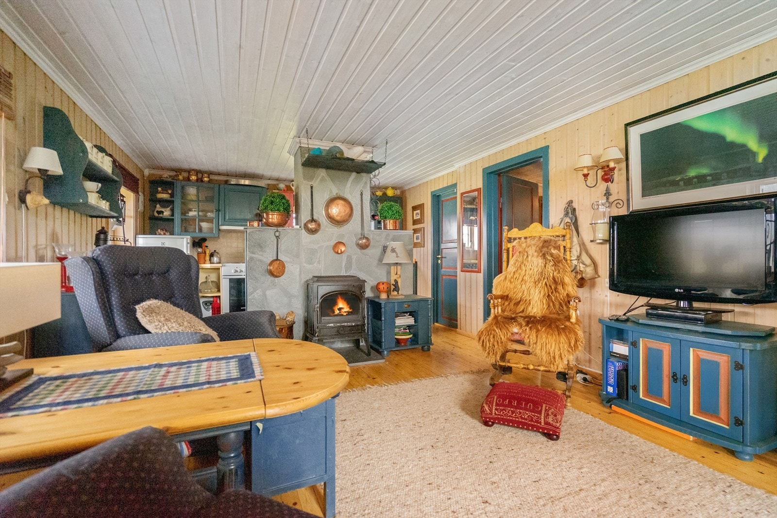 Lys og trivelig stue med panel på både vegger og i tak - gir en hyggelig og hyttekoselig atmosfære i rommet Galleribilde