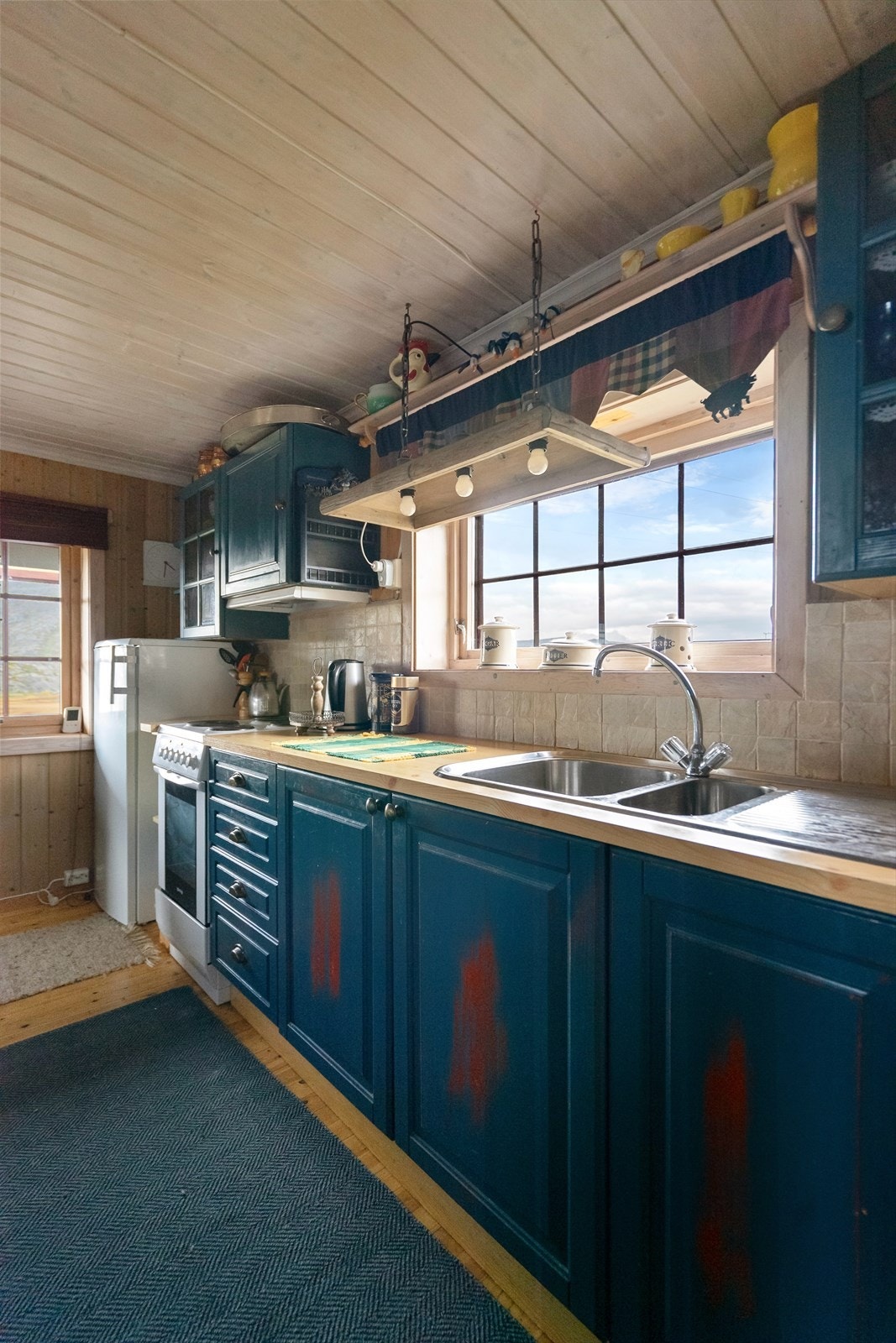 Sjarmerende hyttekjøkken utstyrt med kjøkkenventilator med avtrekk ut, gode arbeidsflater og godt med skapplass Galleribilde