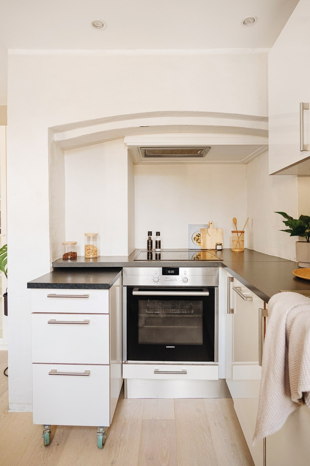 Stilfull detalj med buet "tak" over koketopp. Skuffeseksjon på hjul gir mulighet for ekstra benkeplass. Downlights i himling. Galleribilde