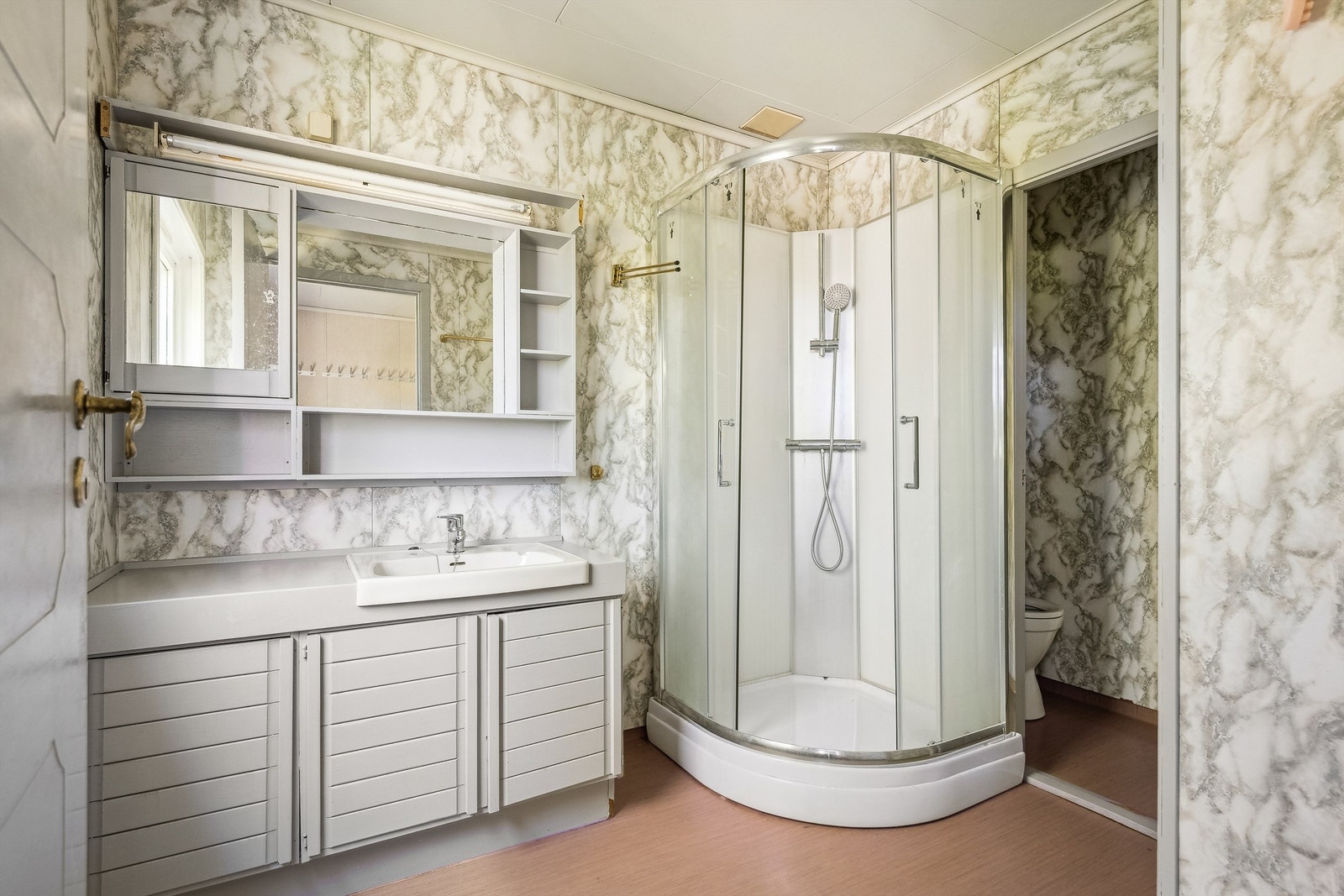 Badet er utstyrt med servantinnredning, toalett i separat rom og dusjkabinett. Galleribilde