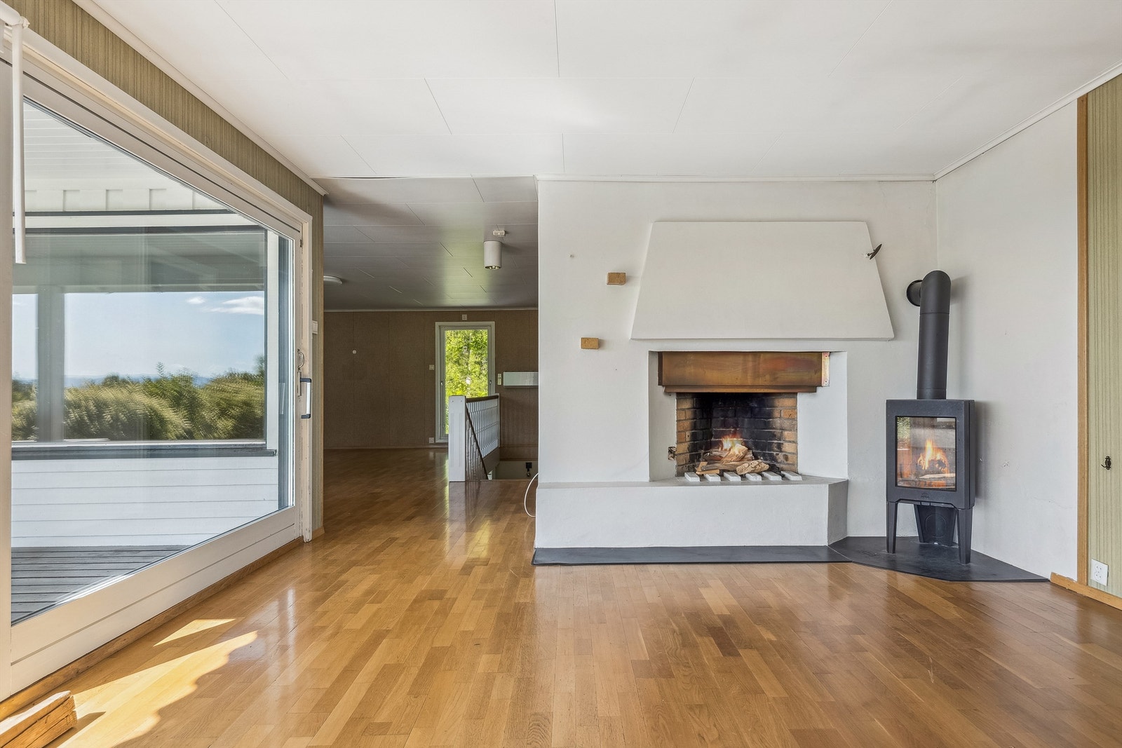 En åpen, murt peis og en Jøtul peisovn gir både varme og en stemningsfull atmosfære. Galleribilde