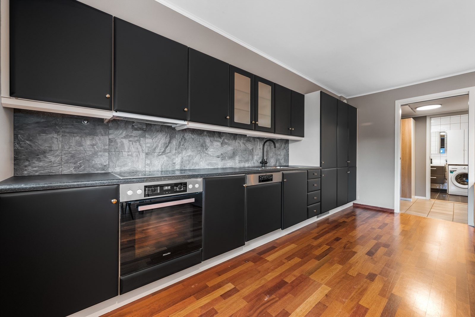 Kjøkkenet har integrerte hvitevarer som kjøl/fryseskap, stekeovn, platetopp og oppvaskmaskin. Galleribilde