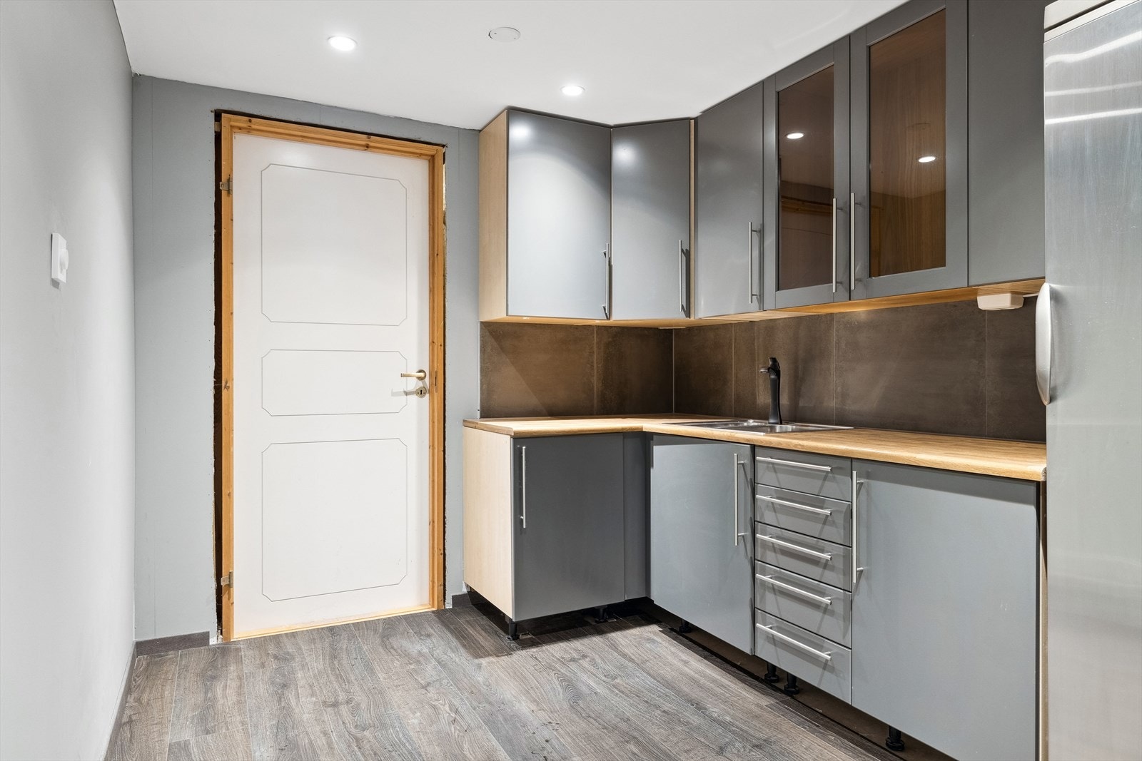 Videre finner vi en eget kjøkken som er innredet med en moderne og lys kjøkkeninnredning med god benk- og skapplass. Galleribilde