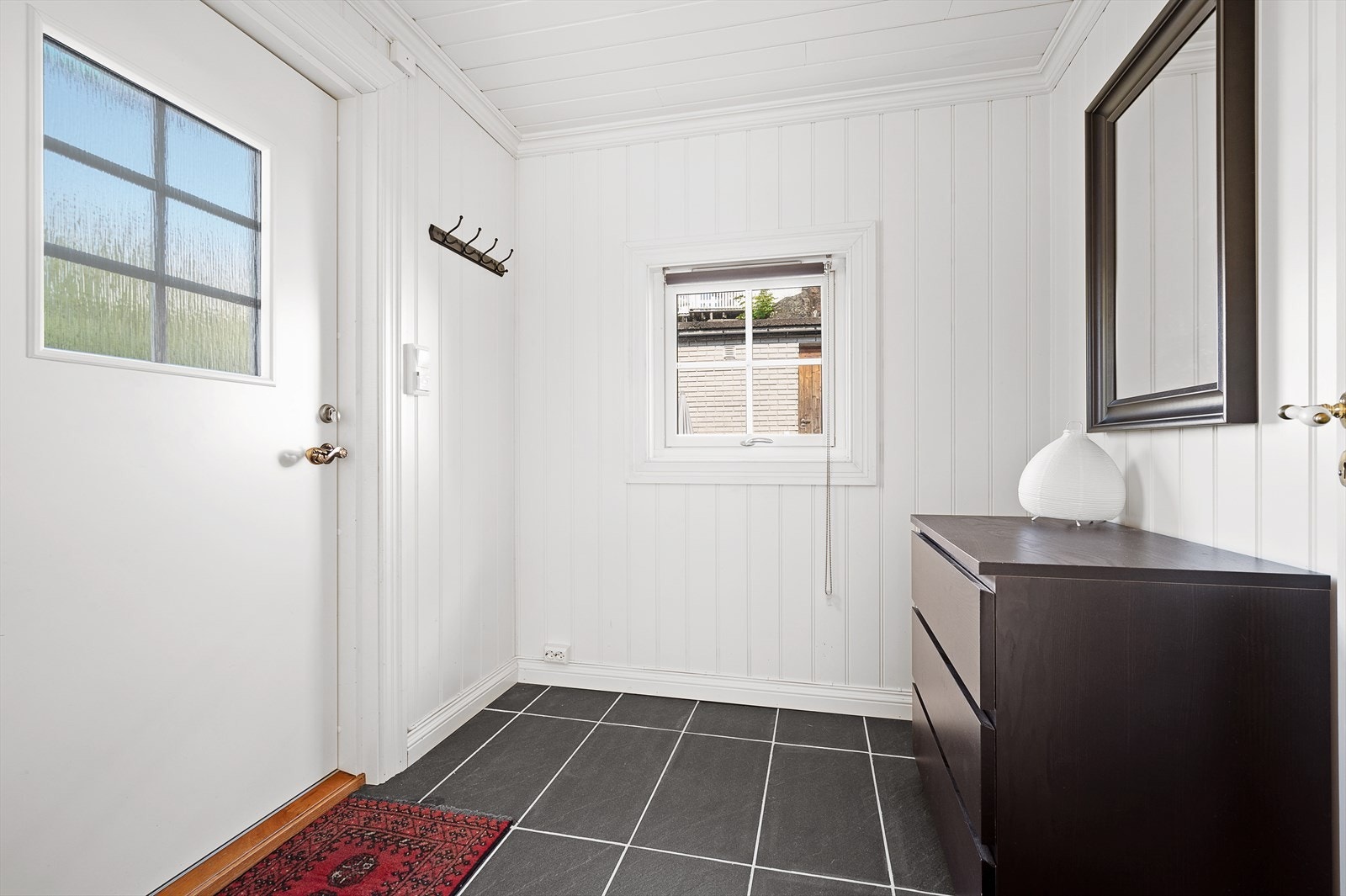 Velkommen inn! Fin og lys entrè med flislagt gulv og varmekabler. Dette er del av tilbygget Galleribilde