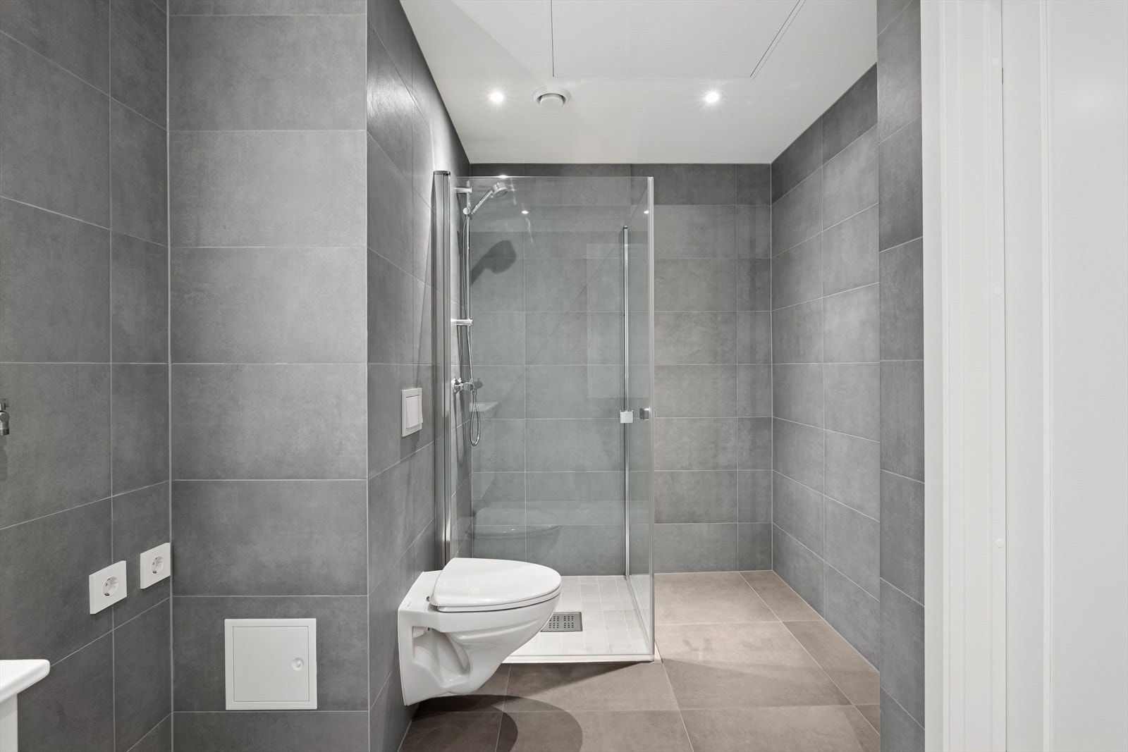 Videre er det dusjhjørne, vegghengt wc og opplegg for vaskemaskin. Galleribilde