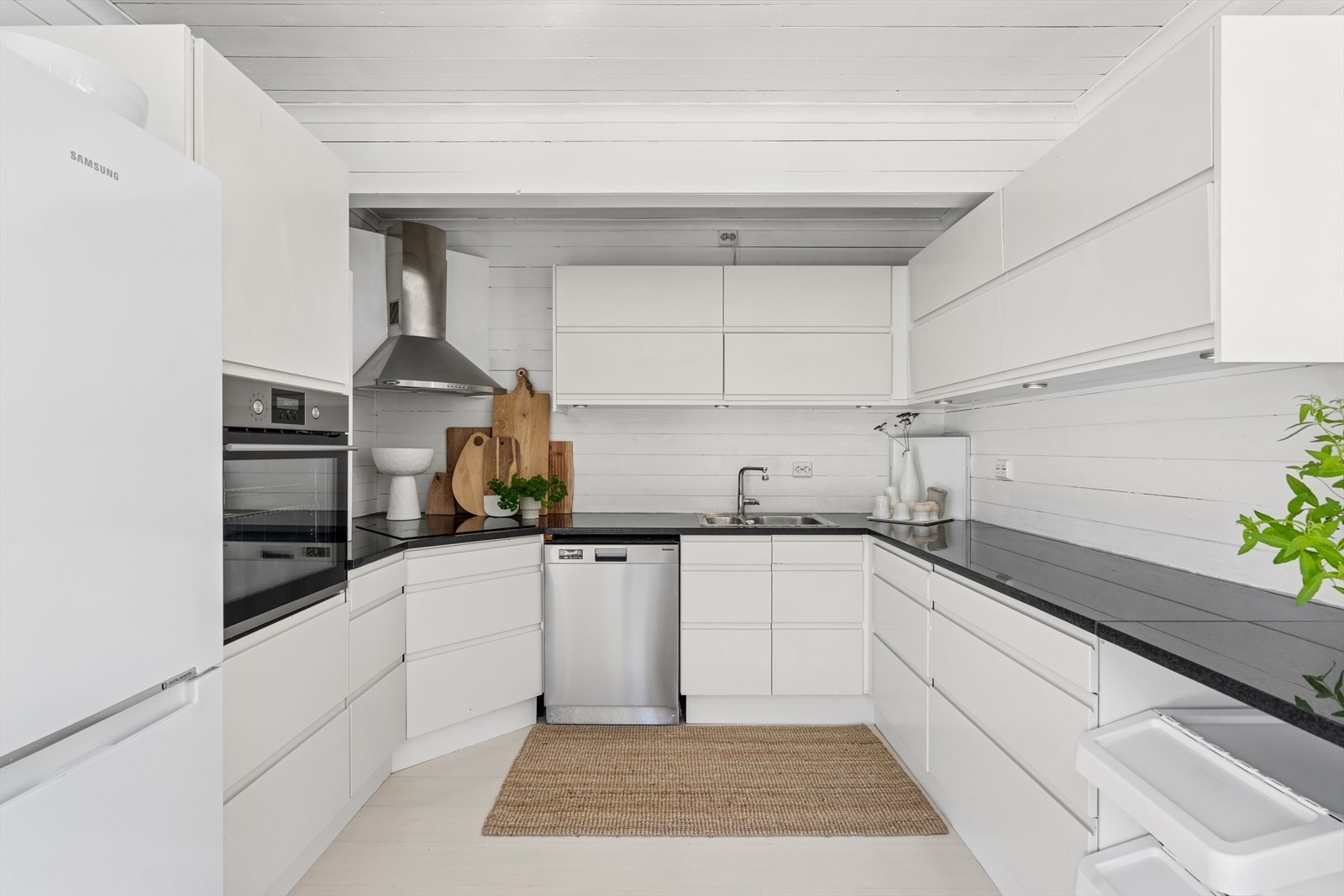 Pent kjøkken fra Designa med integrerte hvitevarer og god skap- og benkeplass. Galleribilde