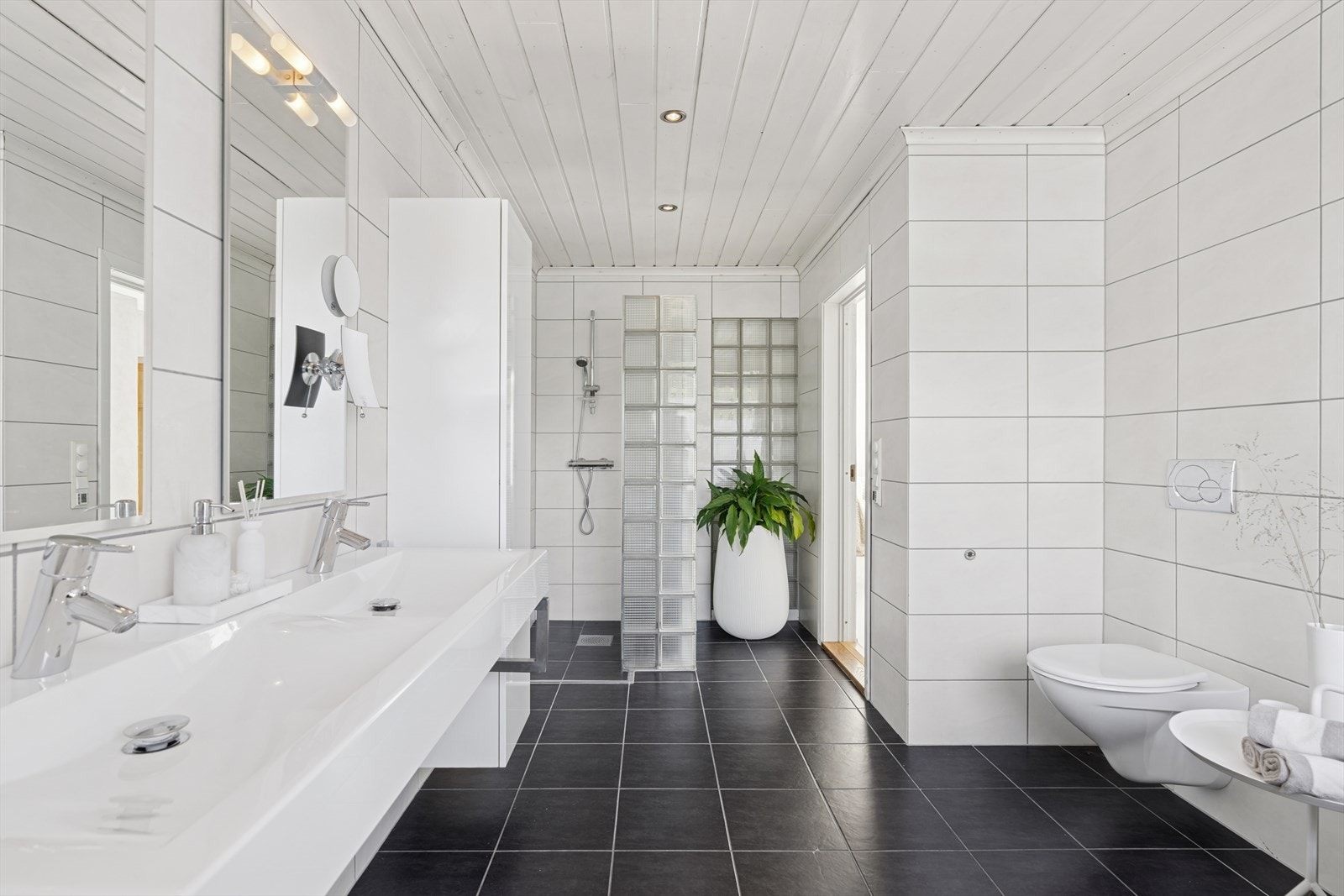 Badet i 1.etg er lyst og pent med fliser og varmekabler i gulv. Galleribilde