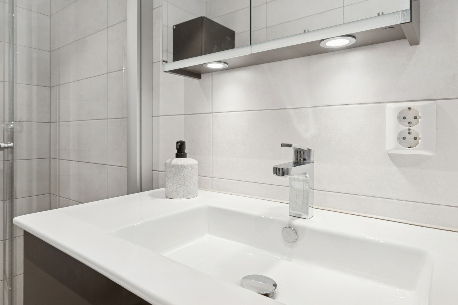 Rommet er innredet med nedfelt servant, toalett og dusjvegger/hjørne. Galleribilde