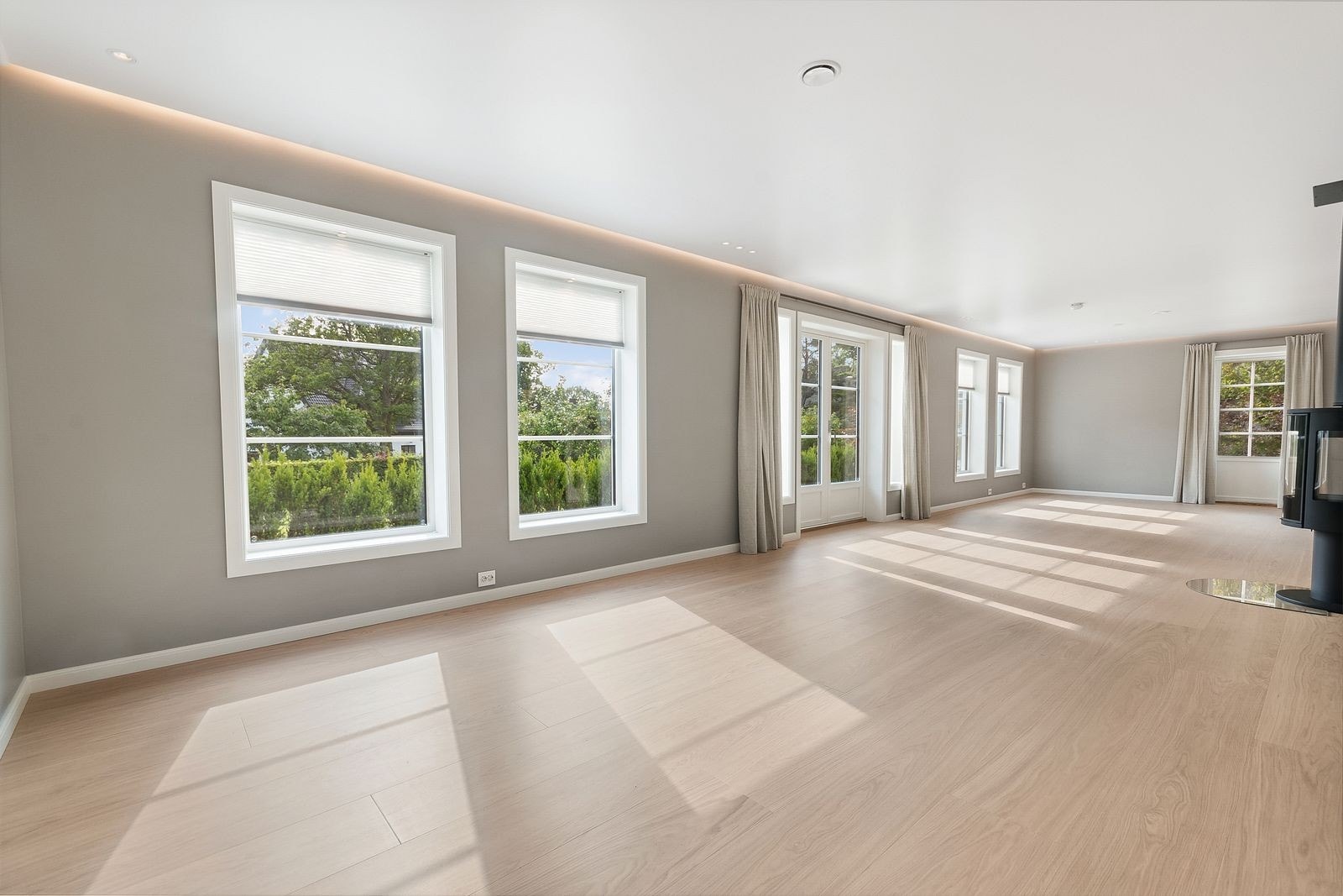 Stue med flotte farger på veggene. Store vindusflater som slipper inn naturlig lys Galleribilde