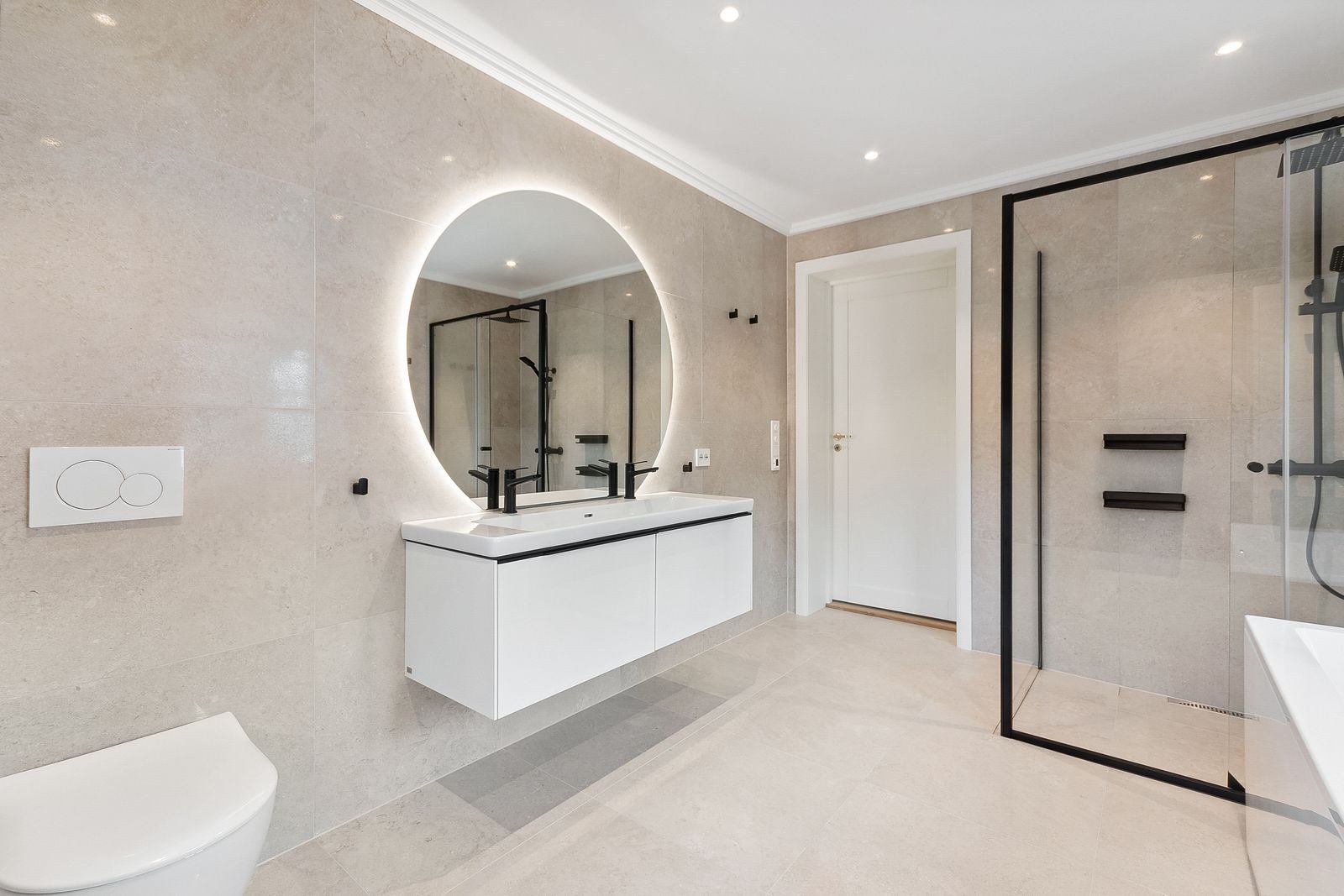 Lekkert flislagt bad med vegghengt toalett, hjørnedusj, badekar og dobbelservant m/innredning Galleribilde