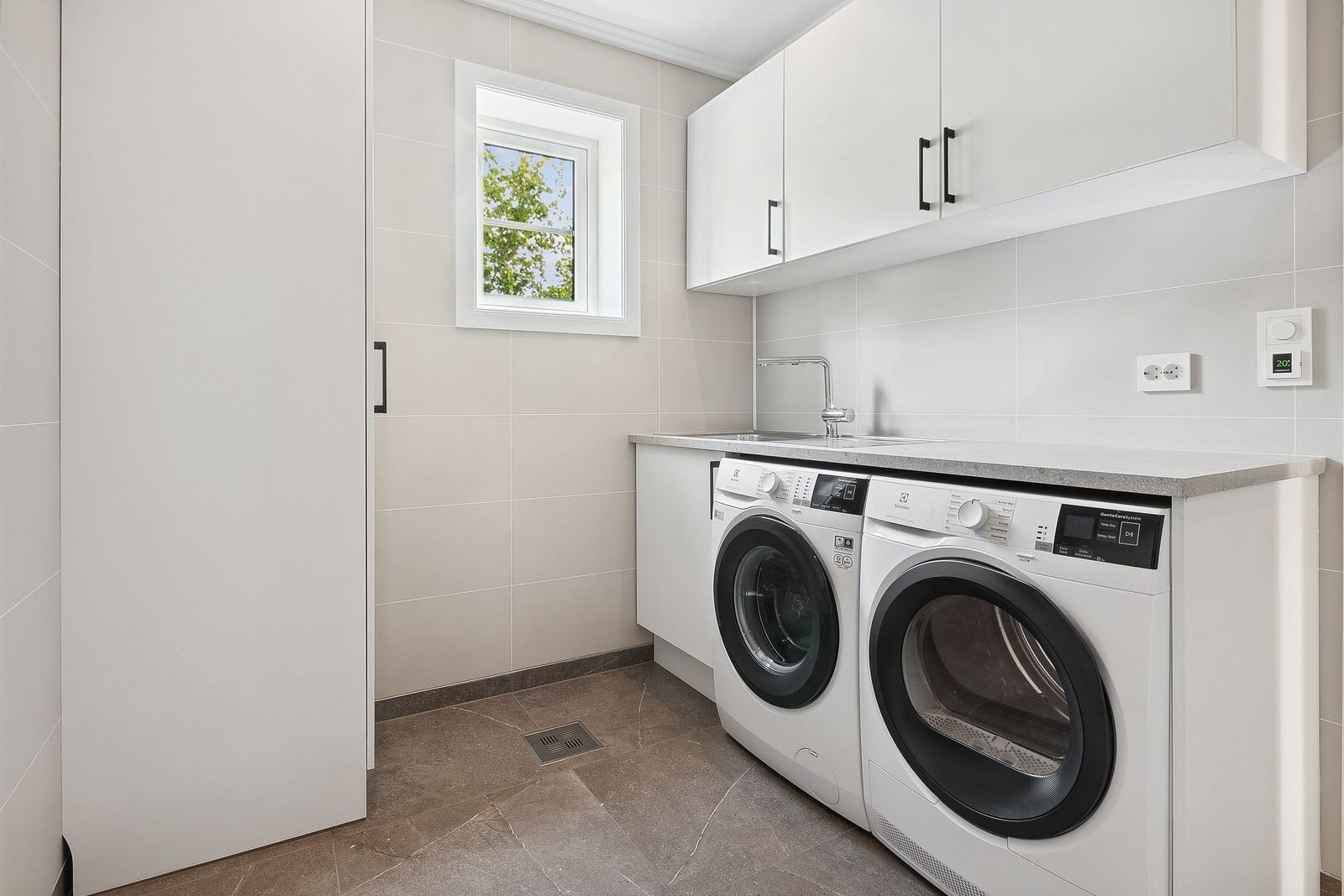 Vaskerom med skap, benkeplass og vask. Vaskemaskin og tørketrommel følger med. Galleribilde