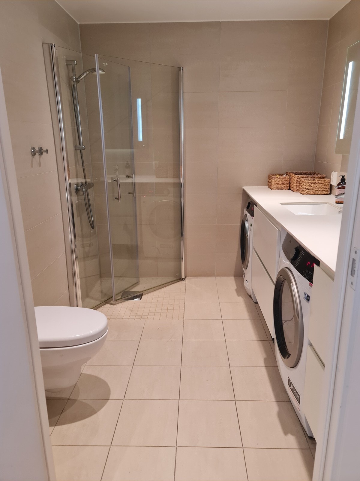 Flislagt baderom med varme i gulv. Vaskemaskin og tørketrommel medfølger. Galleribilde