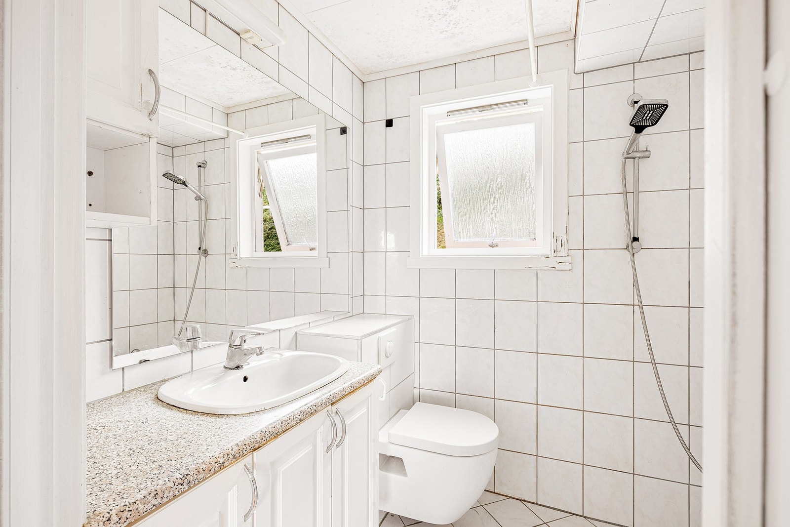 Flislagt bad på 2,8 kvadratmeter som er utstyrt med toalett, servant og dusjhjørne Galleribilde